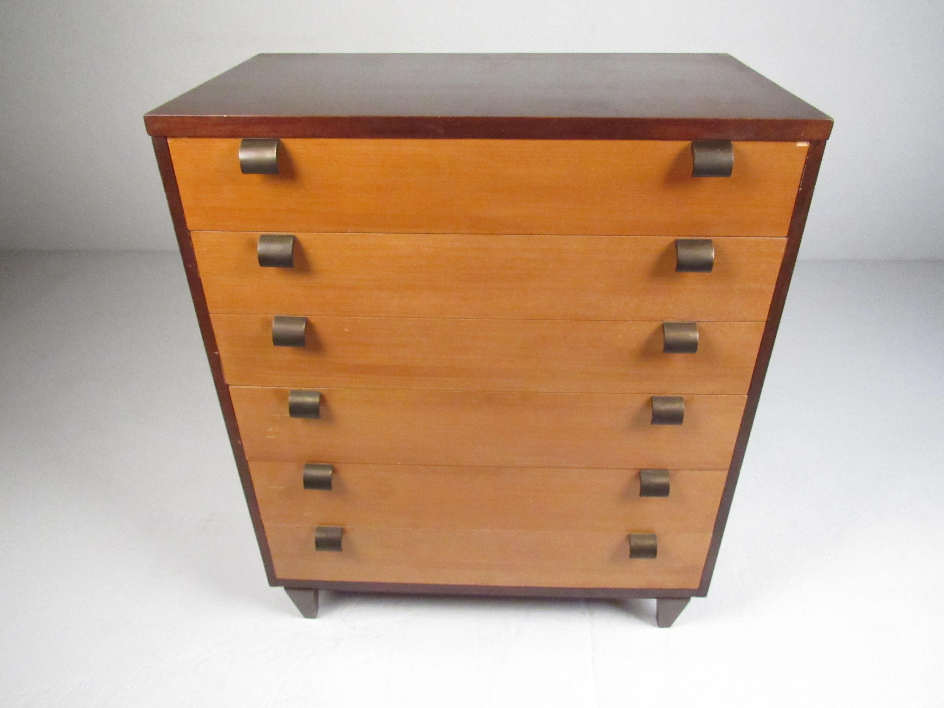 A stunning pair of Mid-Century Modern dressers with unusual curved brass pulls and tapered legs. A two-tone design that offers plenty of room for storage within its many drawers. Please confirm item location (NY or NJ).

Measures: Highboy: 36.25 W