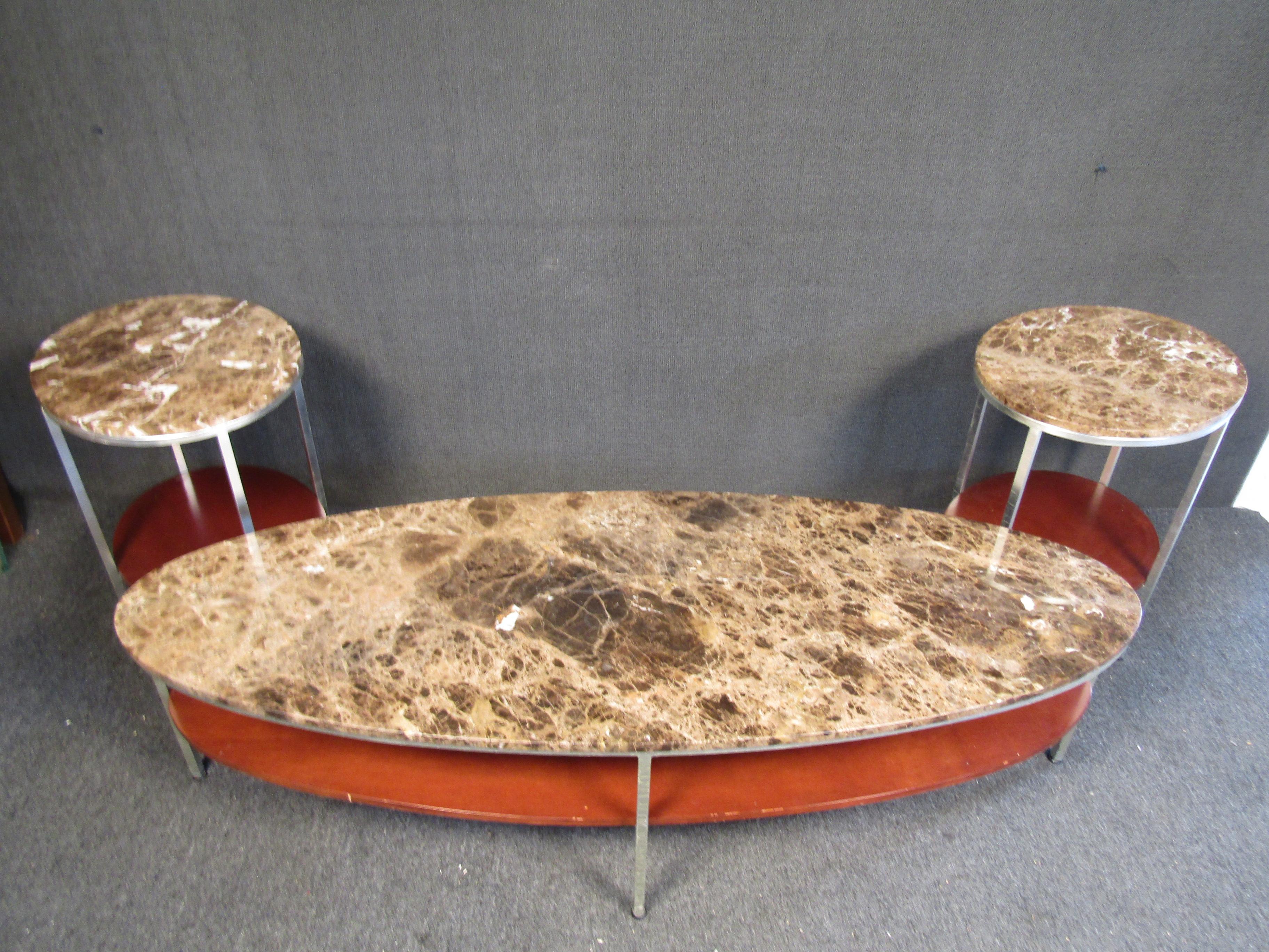 Vintage modern marble and metal coffee table set. This sleek set includes ( 1 ) large oval shaped marble table and ( 2 ) matching end tables. These tables feature an earthy colored oval marble top, metal frames and wooden bottom shelves. 

End