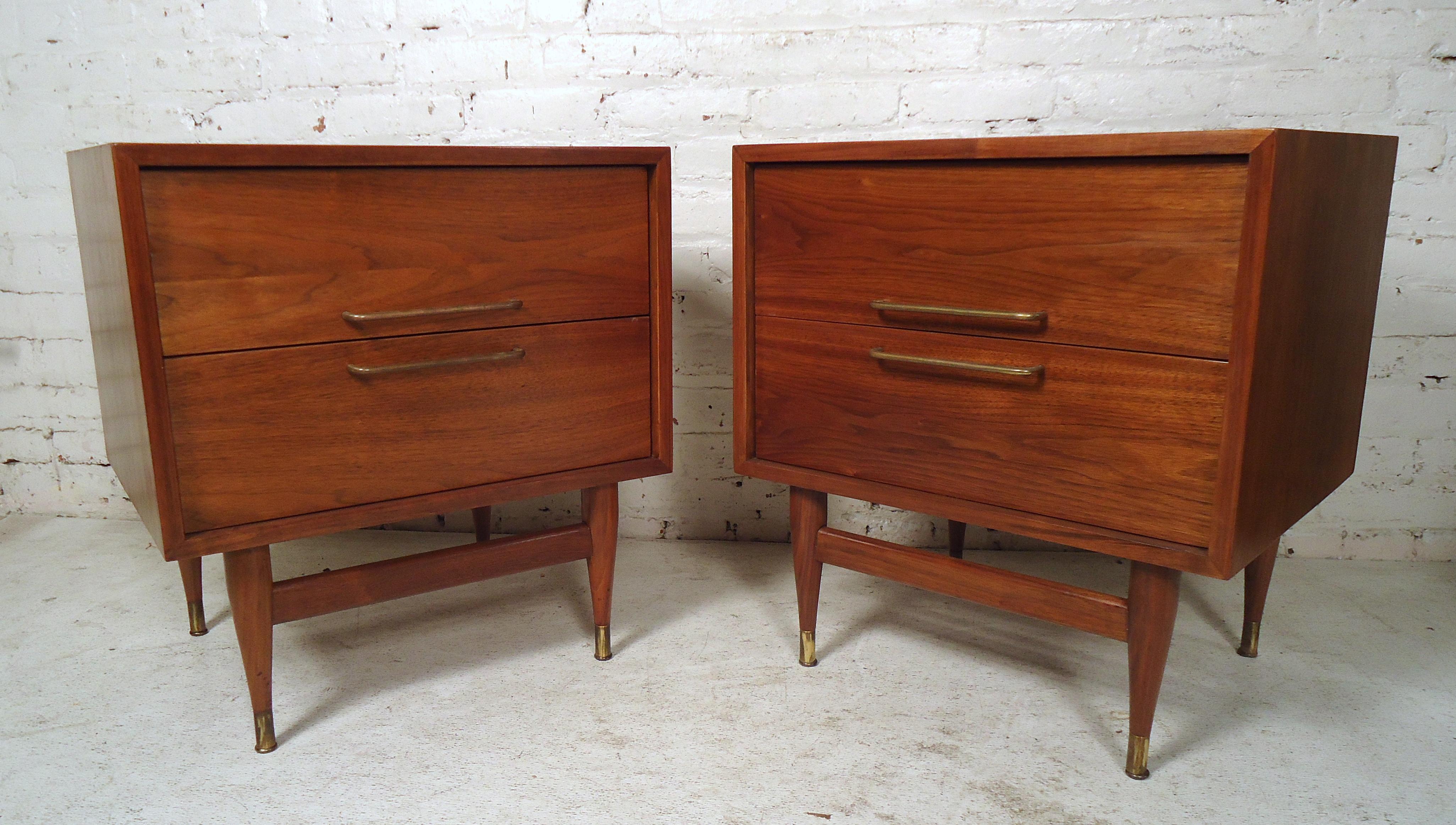 Sleek pair of mid century modern night stands featured in rich walnut grain, two drawers, brass pulls and feet.
(Please confirm item location, NY or NJ, with dealer).