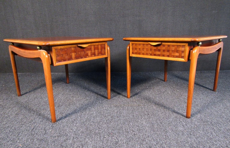 Mid-Century Modern side tables by Lane Furniture. These exquisite tables feature gorgeous walnut grain with oak edging. The thatched drawers with wood handles make these pieces absolutely stunning, and brass accents highlight the beautiful curves of