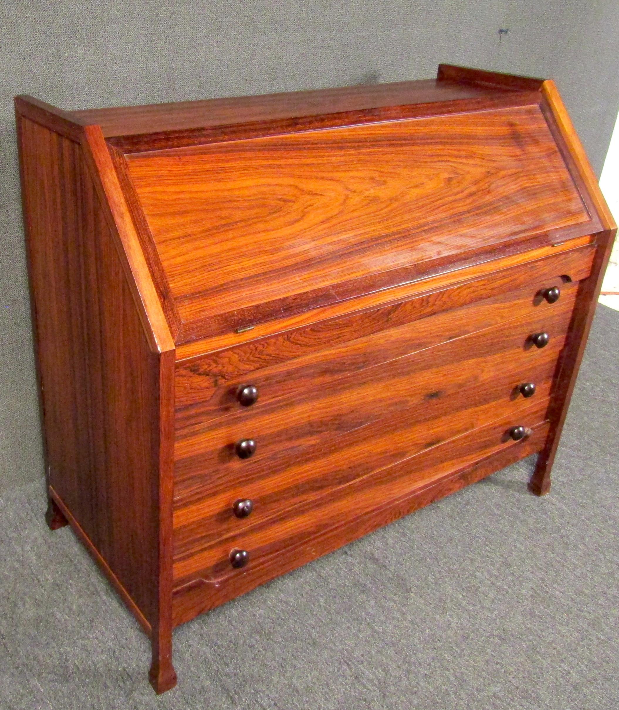 Mid-Century Modern dresser with sculpted trim and wood drawer pulls. This piece features a fold-down desk with brass hinges, storage compartments, and three small drawers. The dresser has four spacious drawers with dove-tail joints.

Please