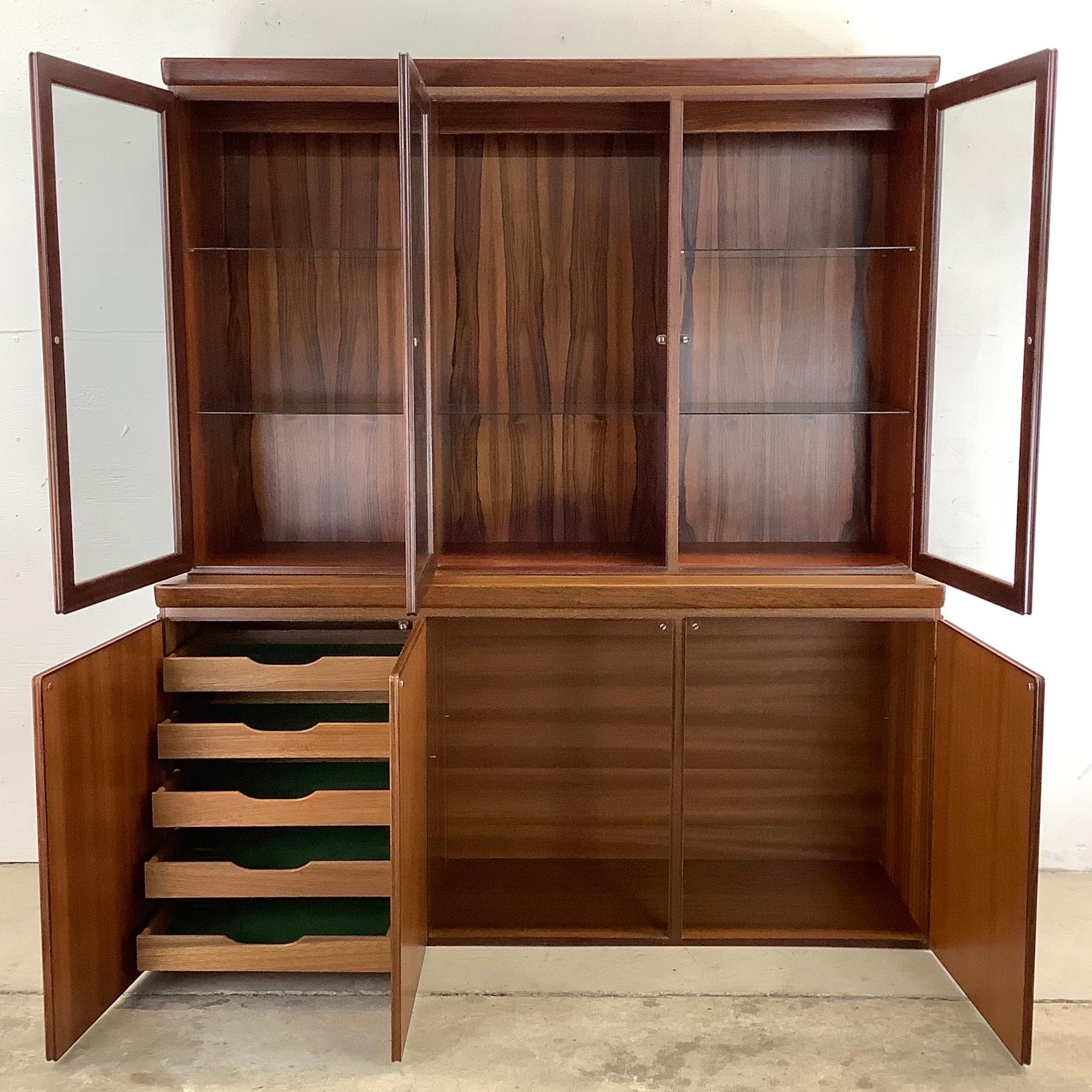 This beautiful Scandinavian modern rosewood sideboard includes a spacious lower cabinet with unique china cabinet topper. The versatile mix of interior cabinet storage, service drawers, and top- lit- shelved display case make this a stunning