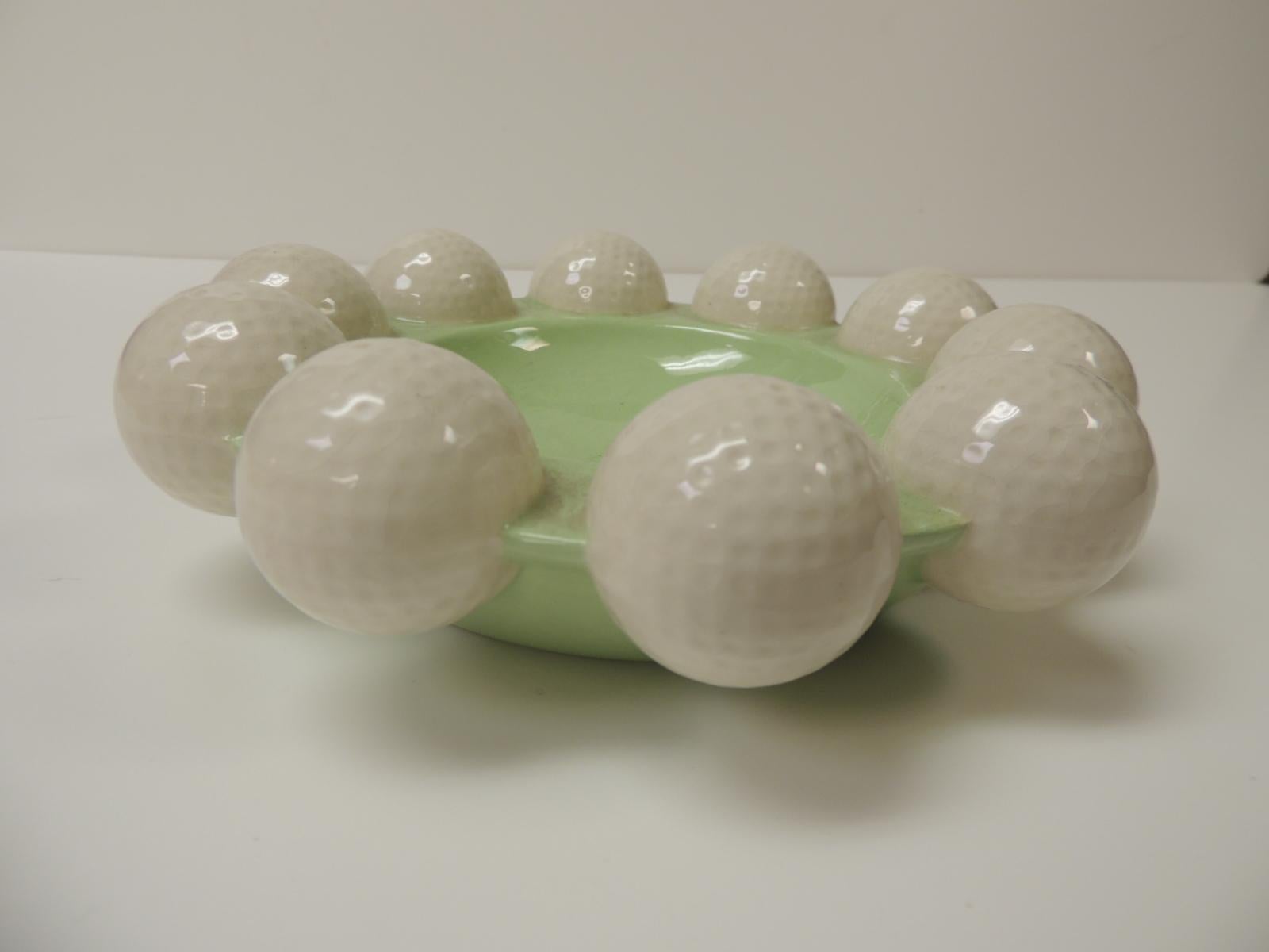 Celadon green and white glazed ceramic round golf balls ashtray from 1980’s Holland with realistic details on the golf balls
Dimensions: 8.5