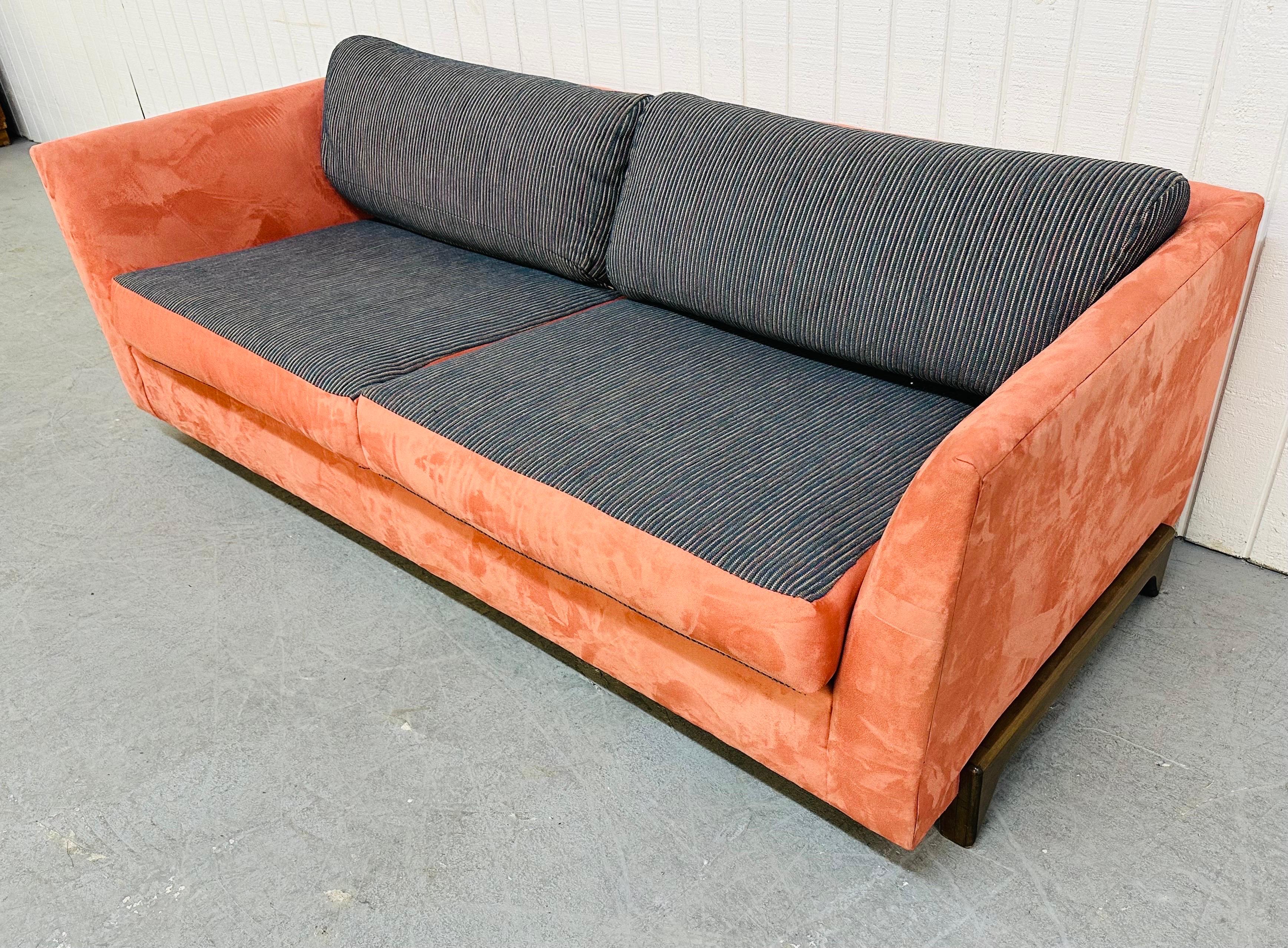 This listing is for a Vintage Modern Salmon Sofa. Featuring two large cushions for seating, walnut legs on the sides, and a beautiful salmon colored upholstery with blue cushions.
