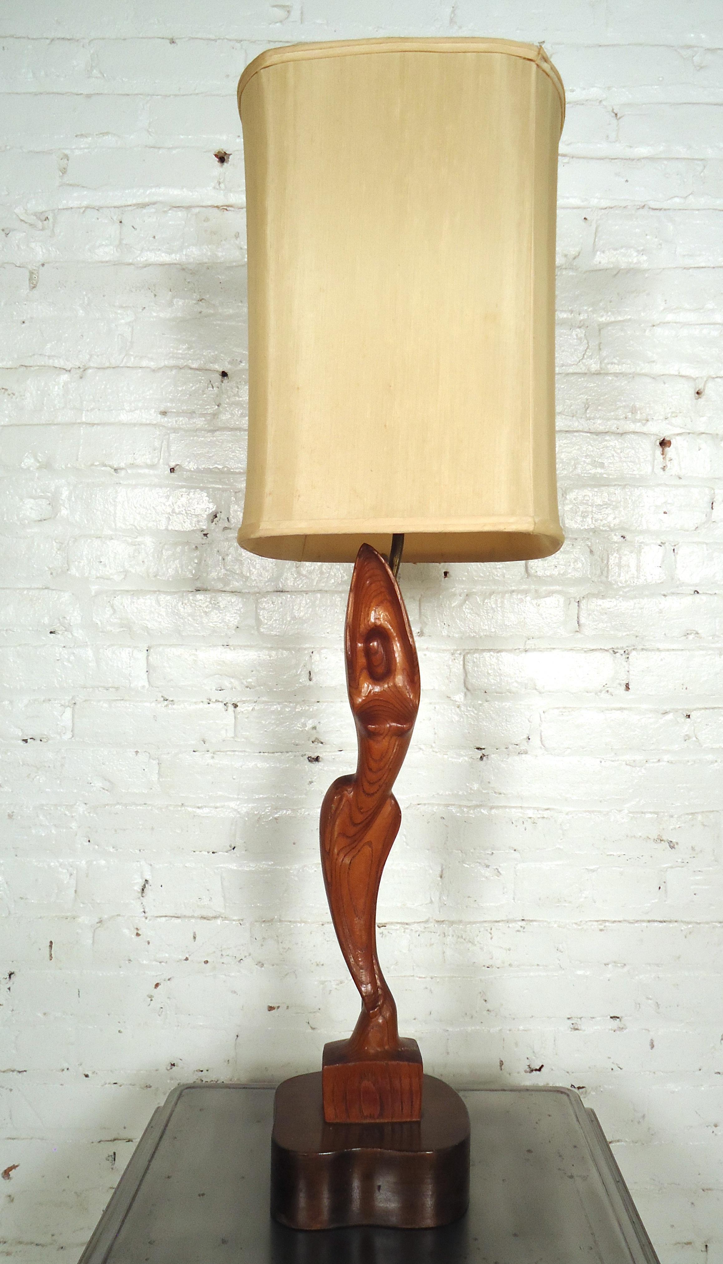 Mid-Century Modern female sculpted table lamp features rich wood grain, solid sturdy base, and shade.
(Please confirm item location - NY or NJ - with dealer).