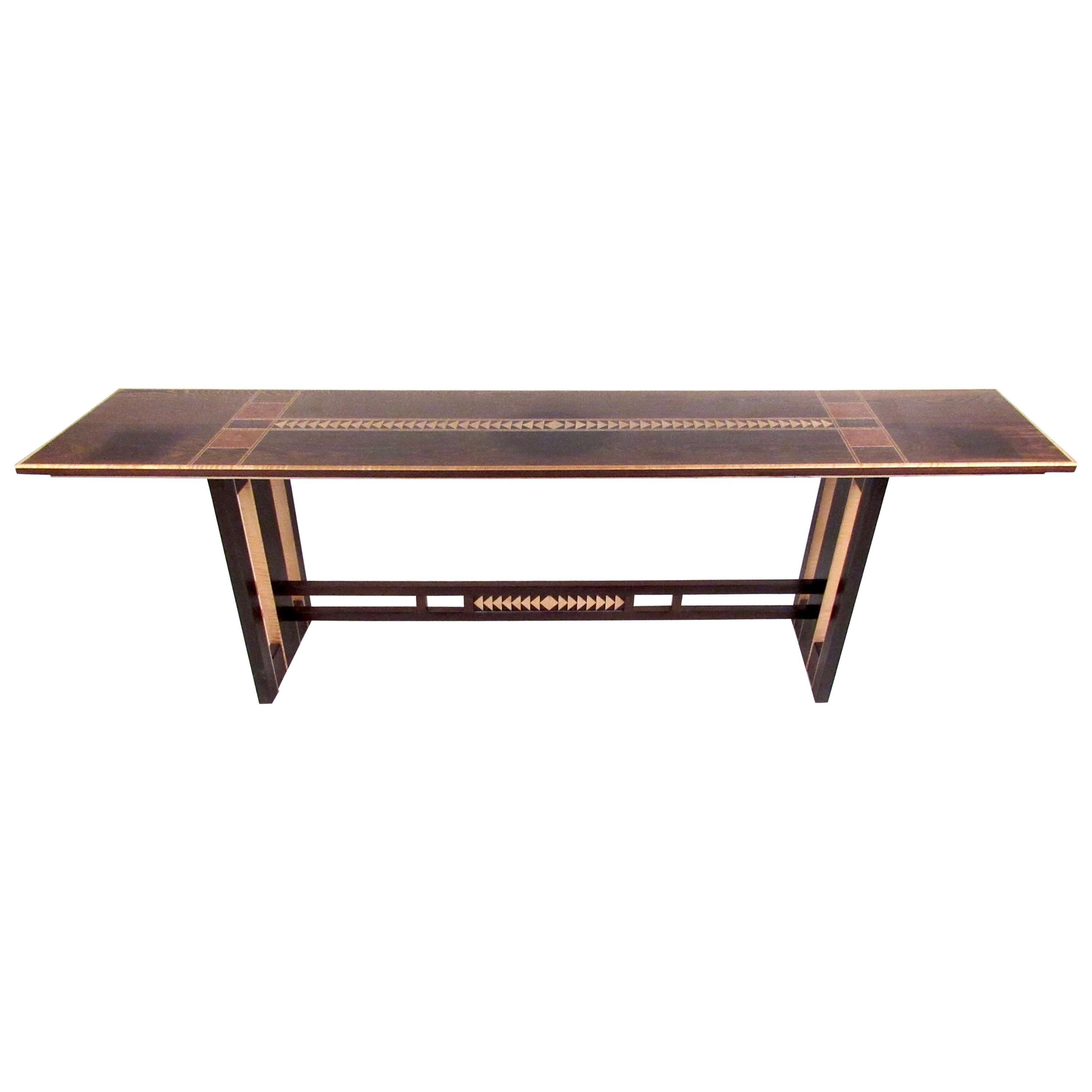 This stunning artist made console table features impressive Nakashima style trestle base and rich natural wood finish. The complimentary wood tones and detailed artistic inlays make this an impressive console or hall table for home or business.