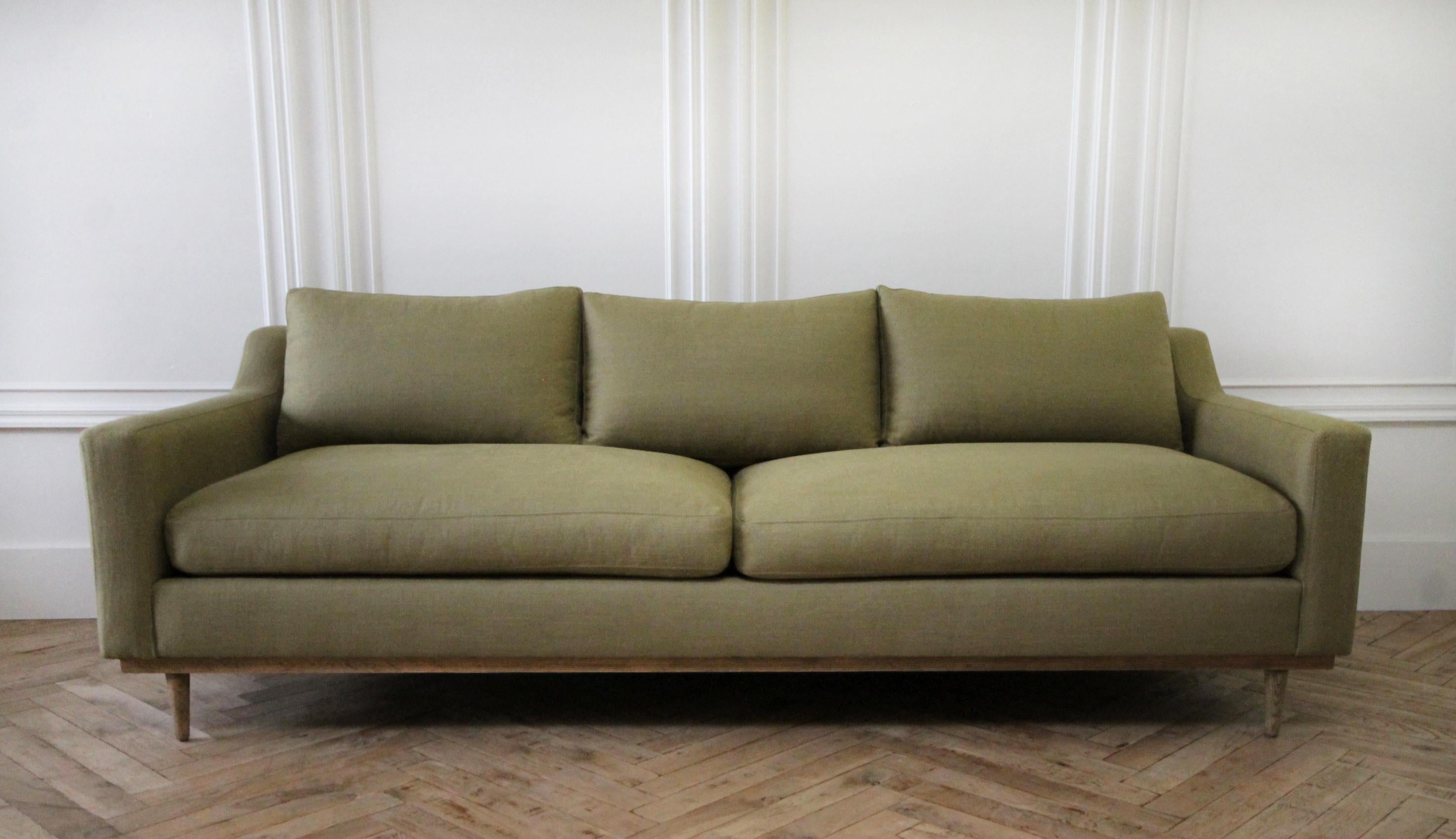 Vintage Modern style sofa with down cushions
Fabric is olive color with herringbone stripe pattern, and down wrapped cushions. There is an light oak show wood base and leg.
Measures: 90