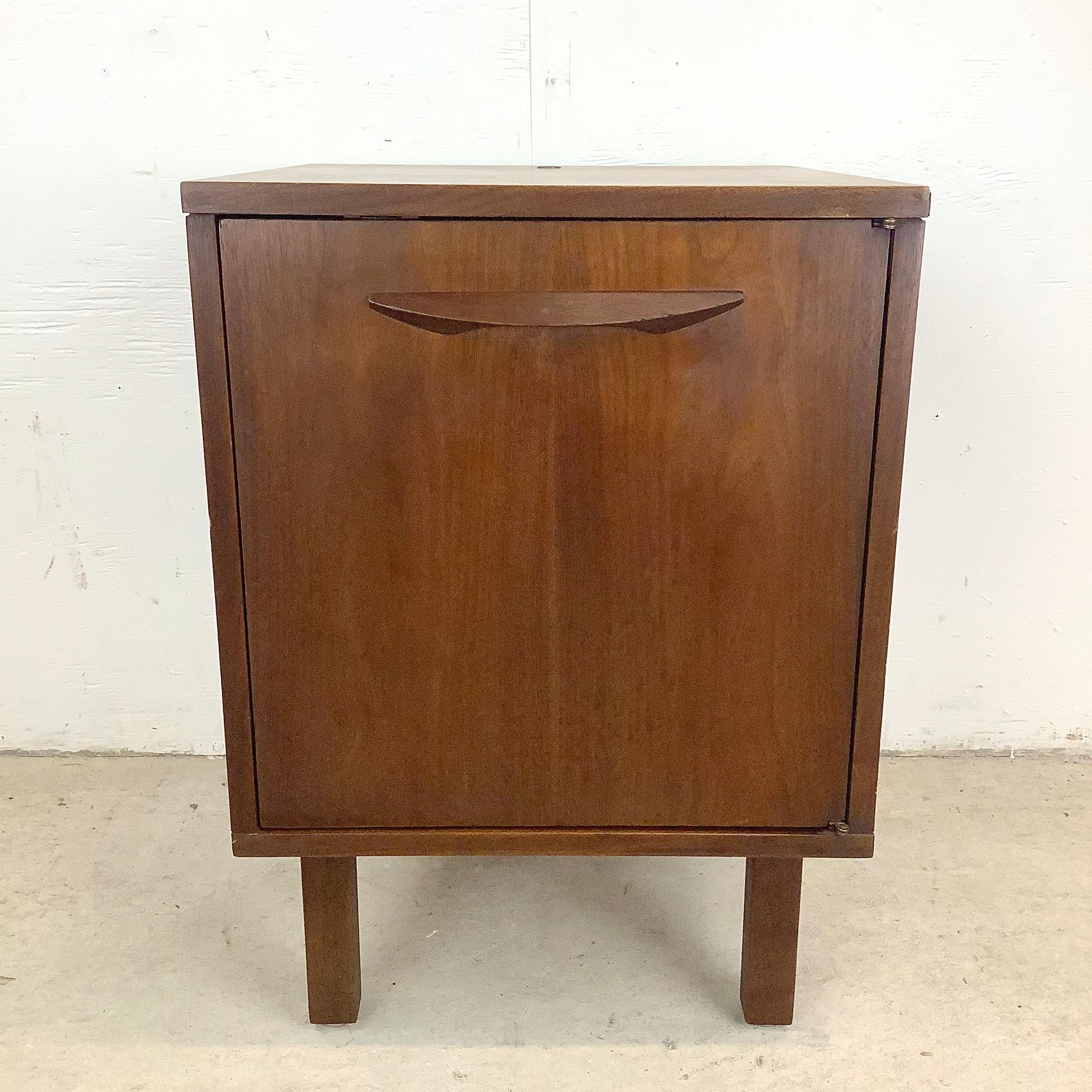 Elegante, audace e tranquillamente sicuro di sé: questo mobile vintage in teak cattura il cuore del design moderno di metà secolo. La struttura sovradimensionata gli conferisce sostanza visiva, mentre l'asta in legno intagliato conferisce arte e
