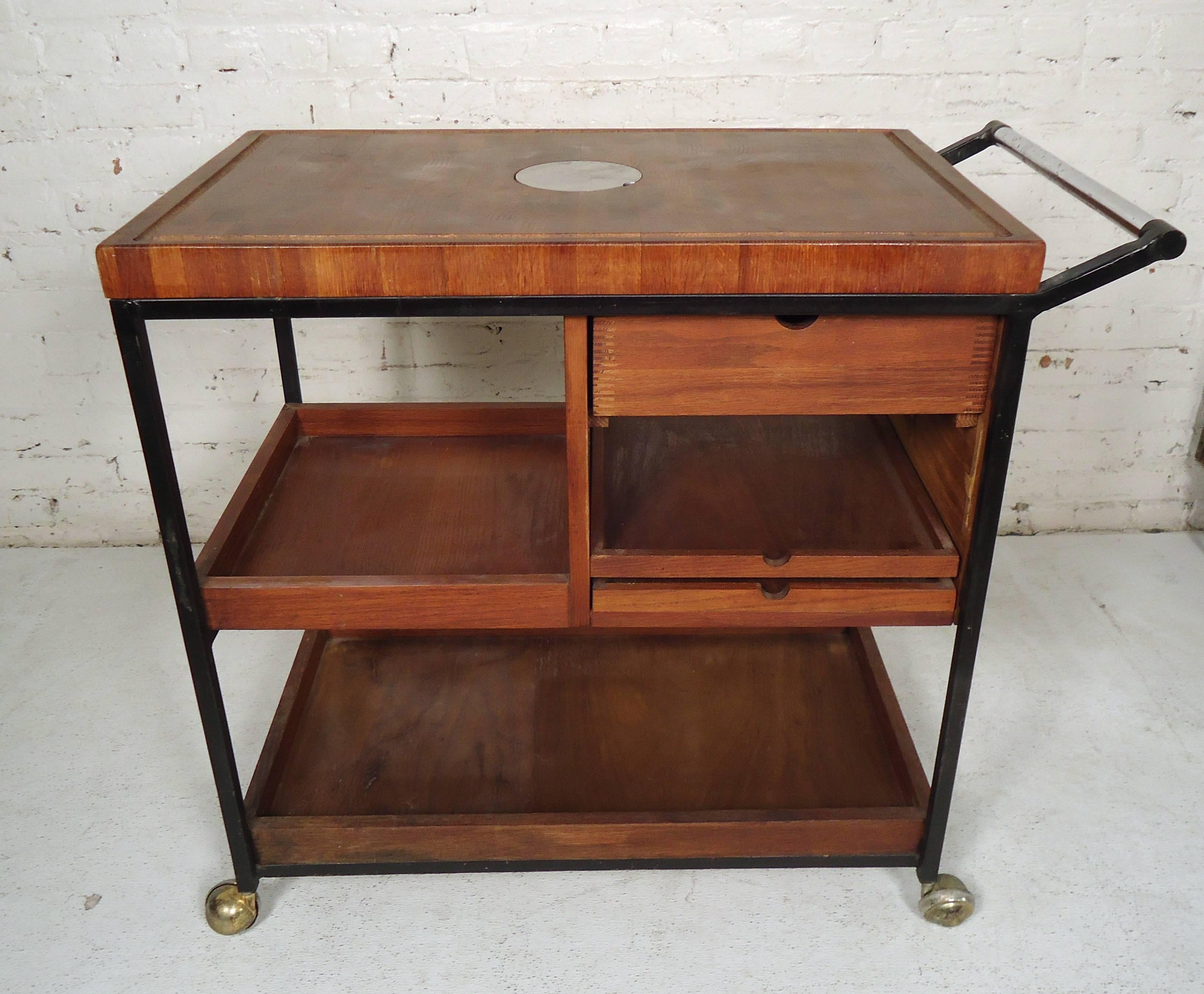 Mid-Century Modern rolling cart features thick butcher block top, shelving and tiers for storage use.

Please confirm item location (NY or NJ).