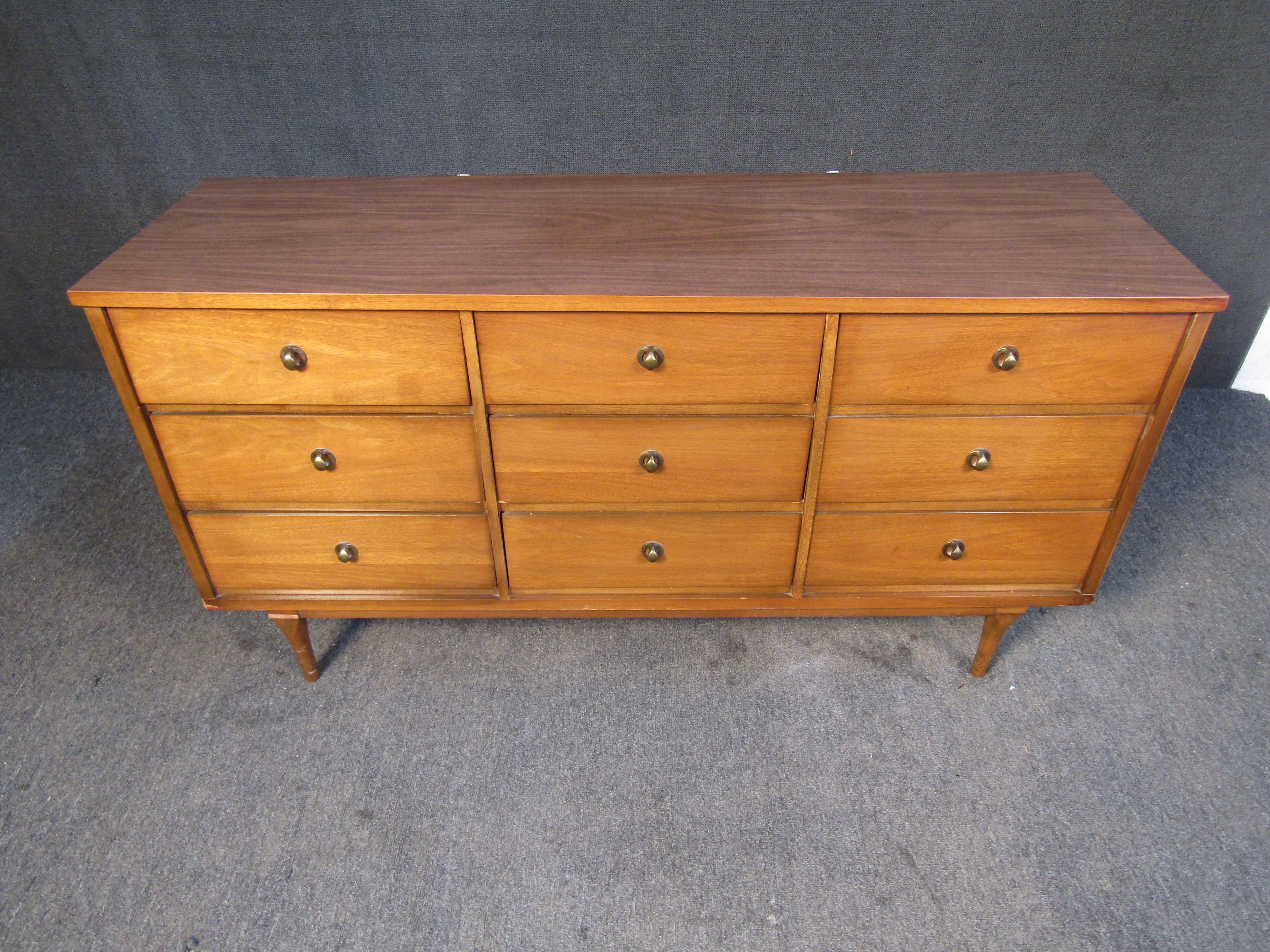 This vintage dresser uses walnut and brass with a Mid-Century Modern design for a timeless look. Please confirm item location with seller (NY/NJ).