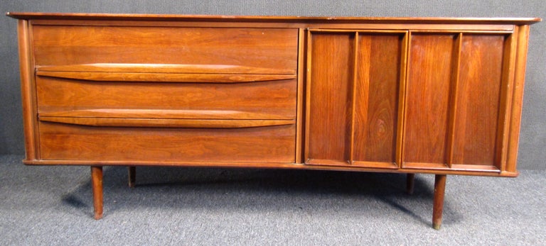 A solid Mid-Century Modern server made of Walnut. It boasts 6 drawers with 3 of them hidden behind detailed doors. Tapered legs perfectly accent the piece and allow it to fit into any office/home setting. Contact seller for pickup location (NY/NJ).