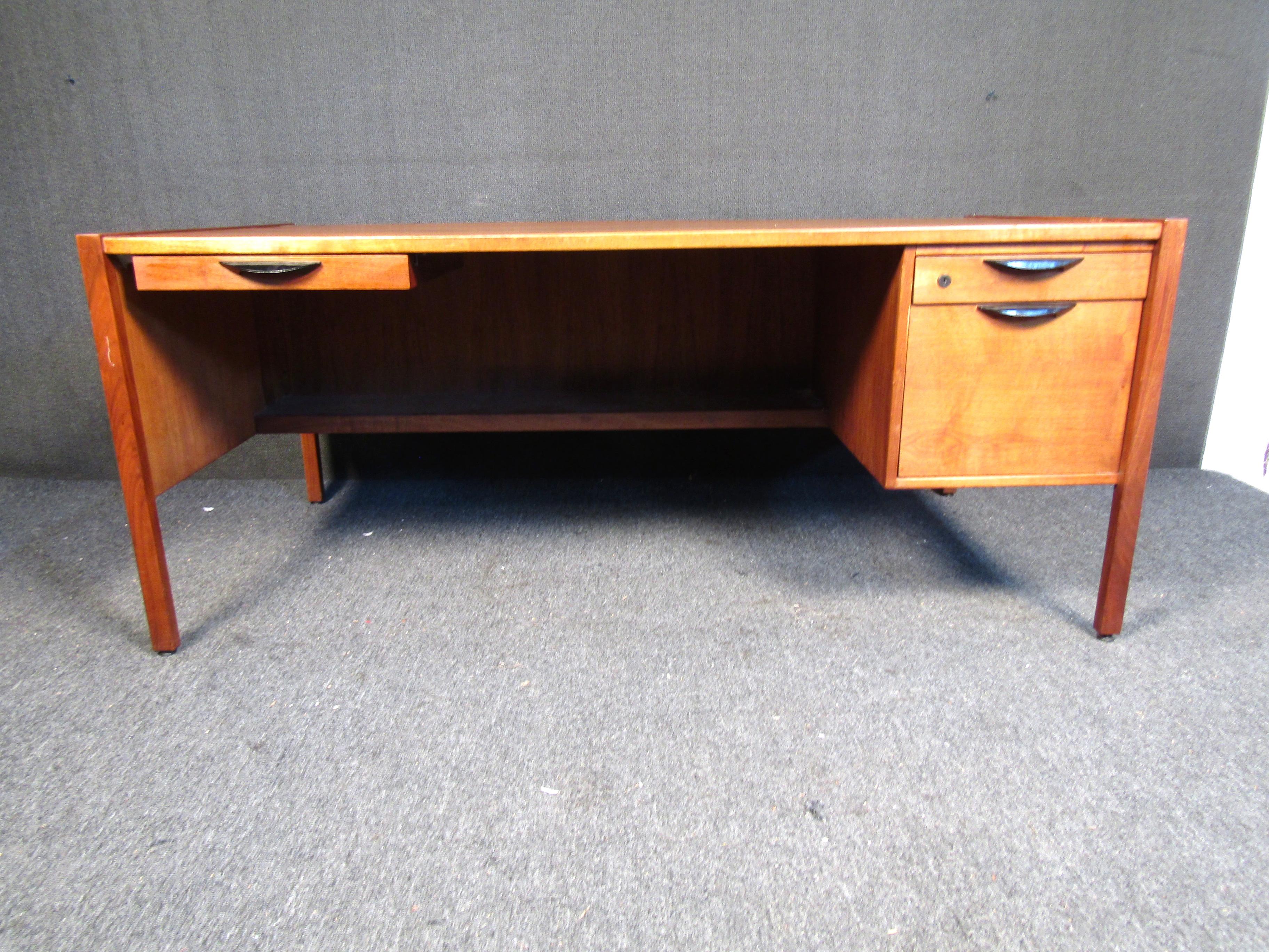 Mid-century modern writing desk by Harvey Probber. This desk features walnut construction, ample leg room, and three drawers for storage of files and odds and ends. A beautiful vintage piece that would add subtle sophistication to any work
