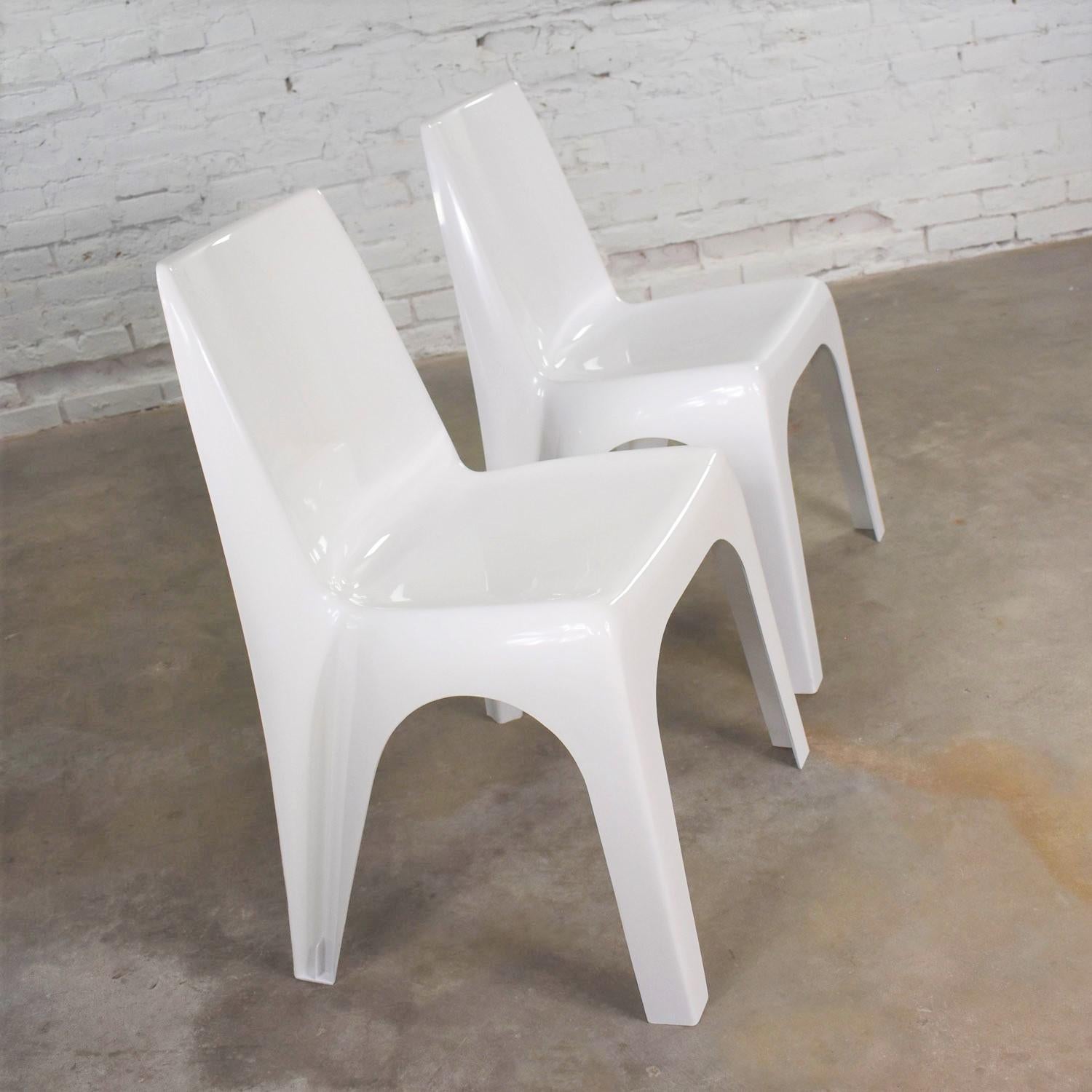 Handsome vintage pair of modern white molded plastic chairs in the style of Kartell’s 4850 chair designed by Giorgina Castiglioni, Geiorgio Gaviraghi, and Aldo Lanza. These are marked USA Patent Pending. They are in wonderful vintage condition. They