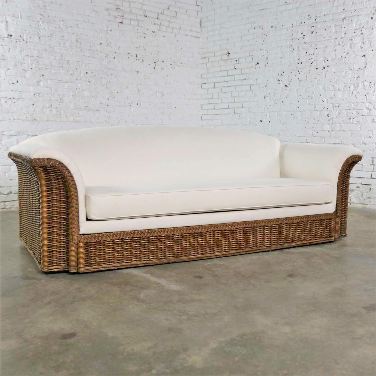 Extraordinary wicker sofa vintage in the manner of Michael Taylor. It has been newly recovered in creamy white cotton canvas. It is in fabulous condition and ready to use. Please see photos, circa mid-late 20th century.

Ok. We are in love with