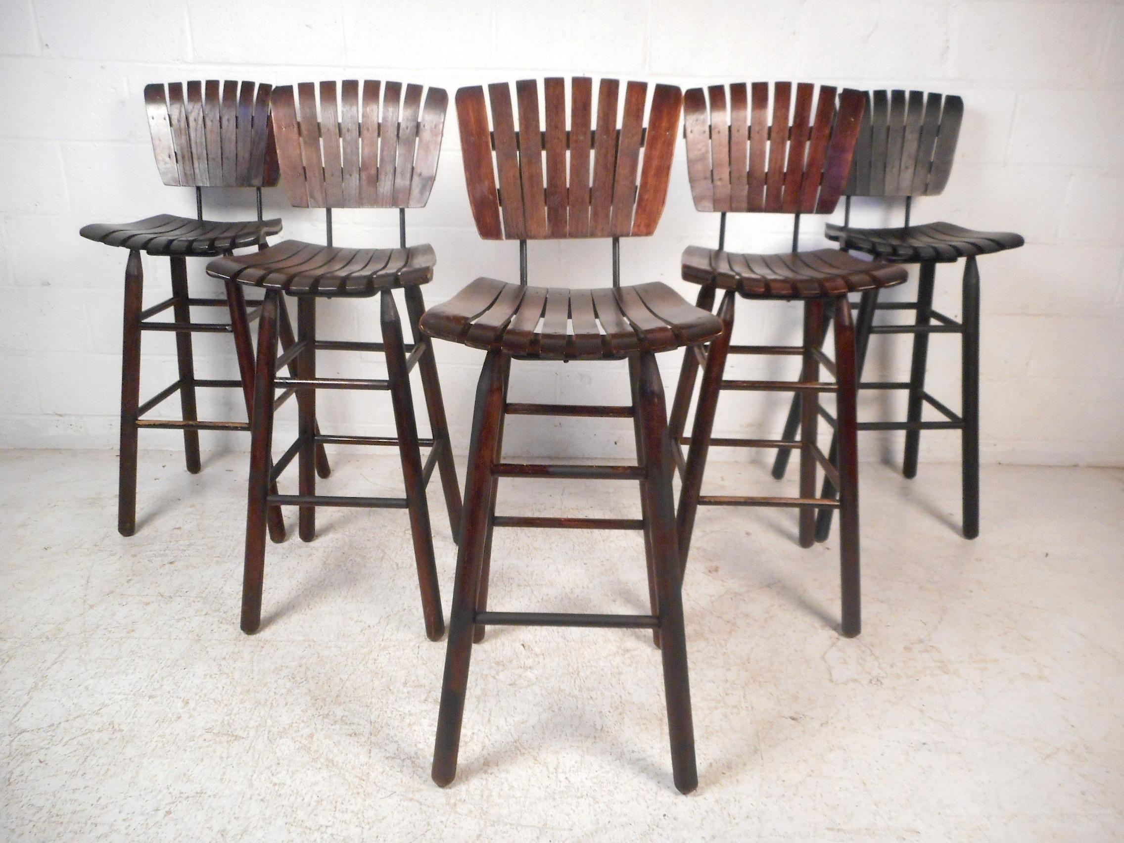 Stylish set of 5 vintage stools. Wooden slat seats and backs. Long tapered legs with two tiers of foot-rests. A great addition to any home's interior decor. Please confirm item location with dealer (NJ or NY).