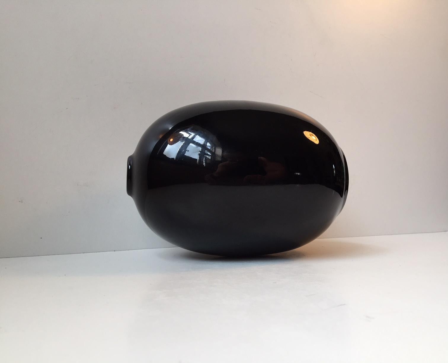 This monochrome black stoneware vase from the 1960s or 1970s is designed in the shape of an egg. Manufactured by Hoganas in Sweden - stamped to the base. Designer: Anonymous.