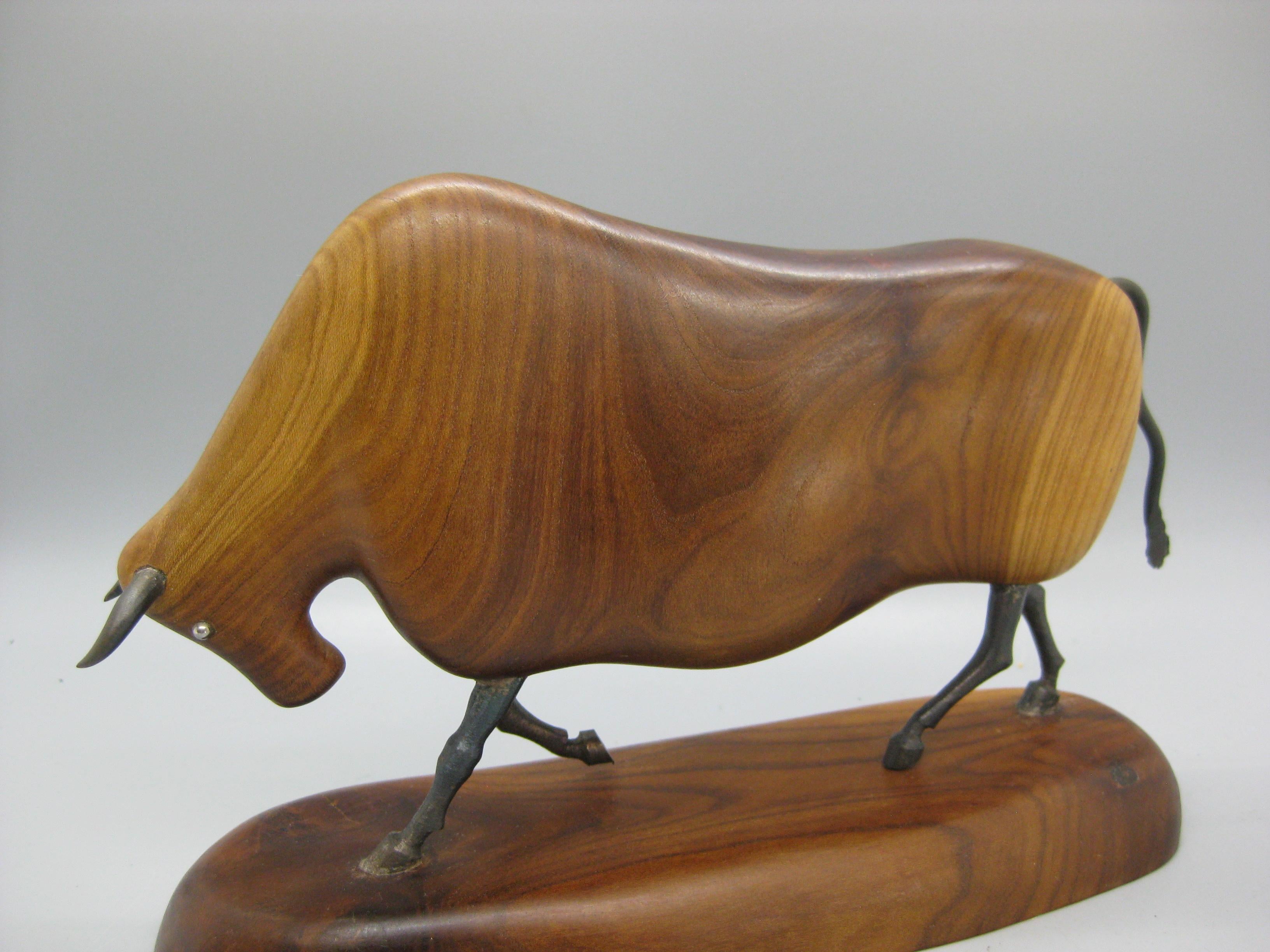 We are offering a wonderful modernist Bull figural sculpture carving. The sculpture was hand carved. Made of wood and has wrought iron horns, legs and tail. Signed on the bottom by the artist. I am not sure who the artist was. Wonderful form and