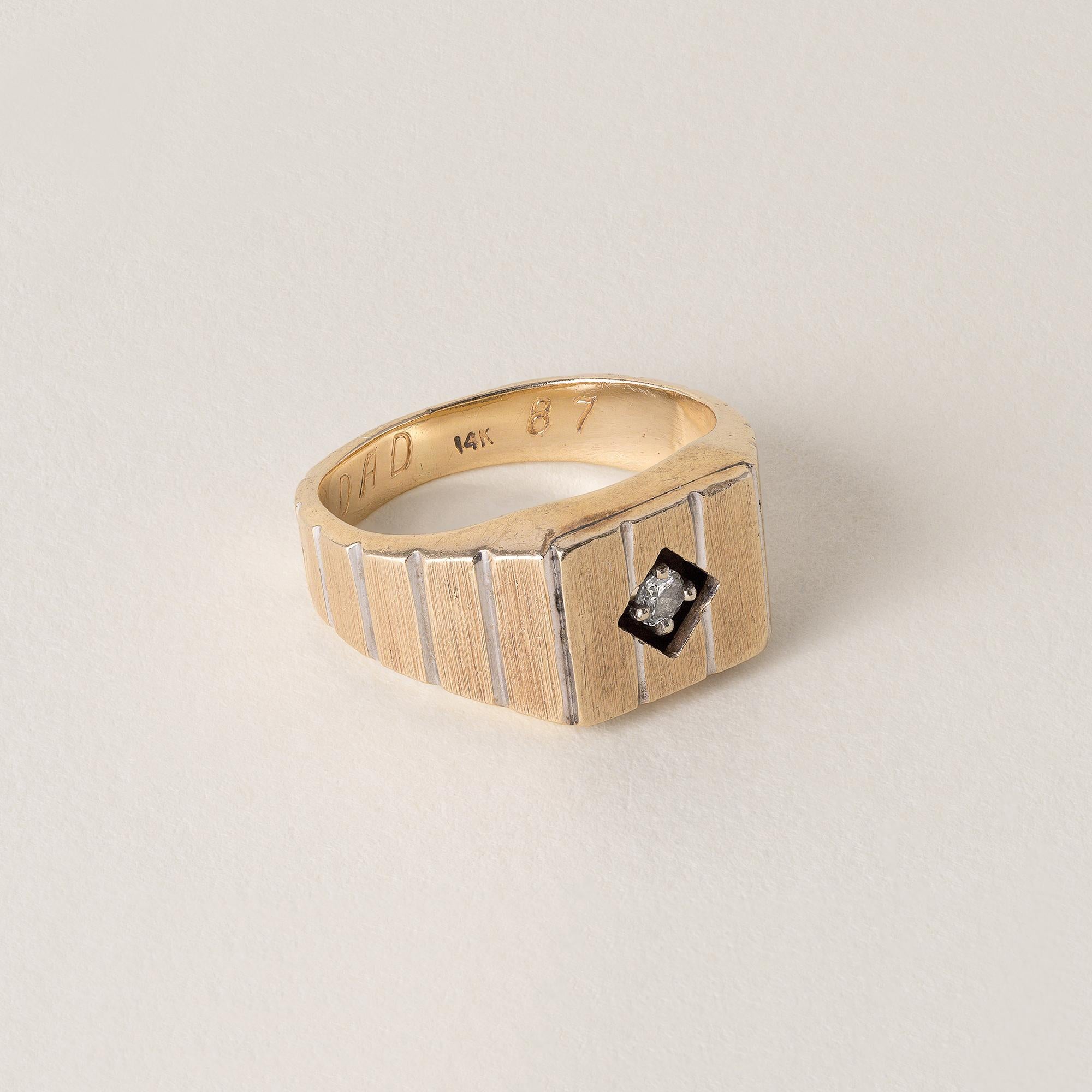 Circa 1950
One round brilliant diamond weighs 0.05 carats H-I SI
The diamond is prong set within a diamond shaped cutout , giving it a sleek, floating appearance
Sleek modern striped pattern along the top and band
6.9 grams
Ring size 7.25
The band