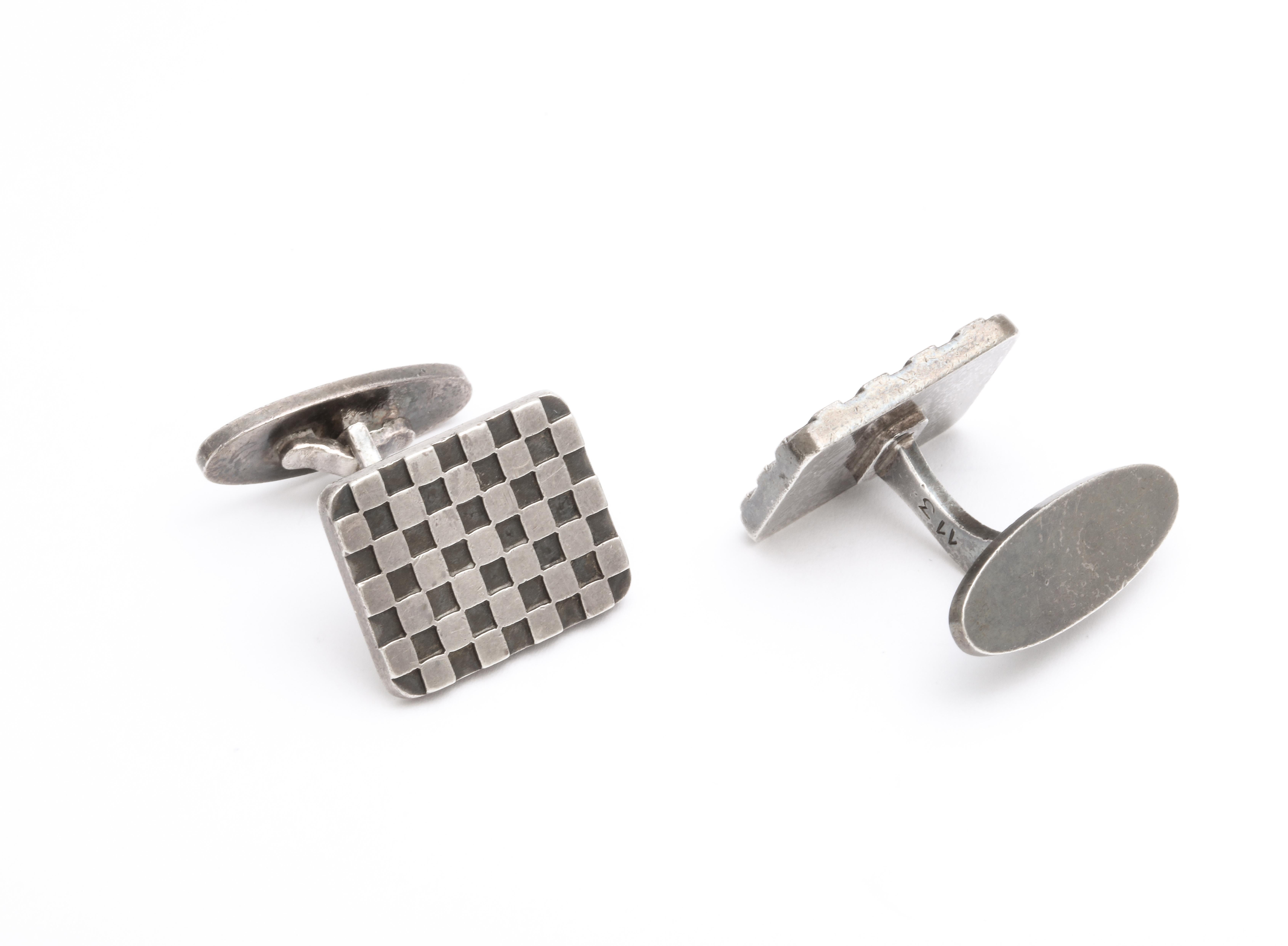 Cufflinks in the design of a checkerboard were made in the mid 20th century by Flemming Eskildsen, a designer for Georg Jensen. 
The design, #113, is recognizable from the game of checkers and was turned into colorful wood boards in the late 1800's