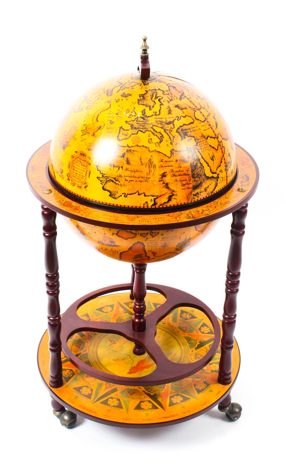 This is a Modernist midcentury cocktail drinks cabinet in the form of a globe, circa 1960 in date.

The hinged top section opens to reveal a fitted interior with spaces for glasses and a ice bucket. The turned tripod legs are joined by an