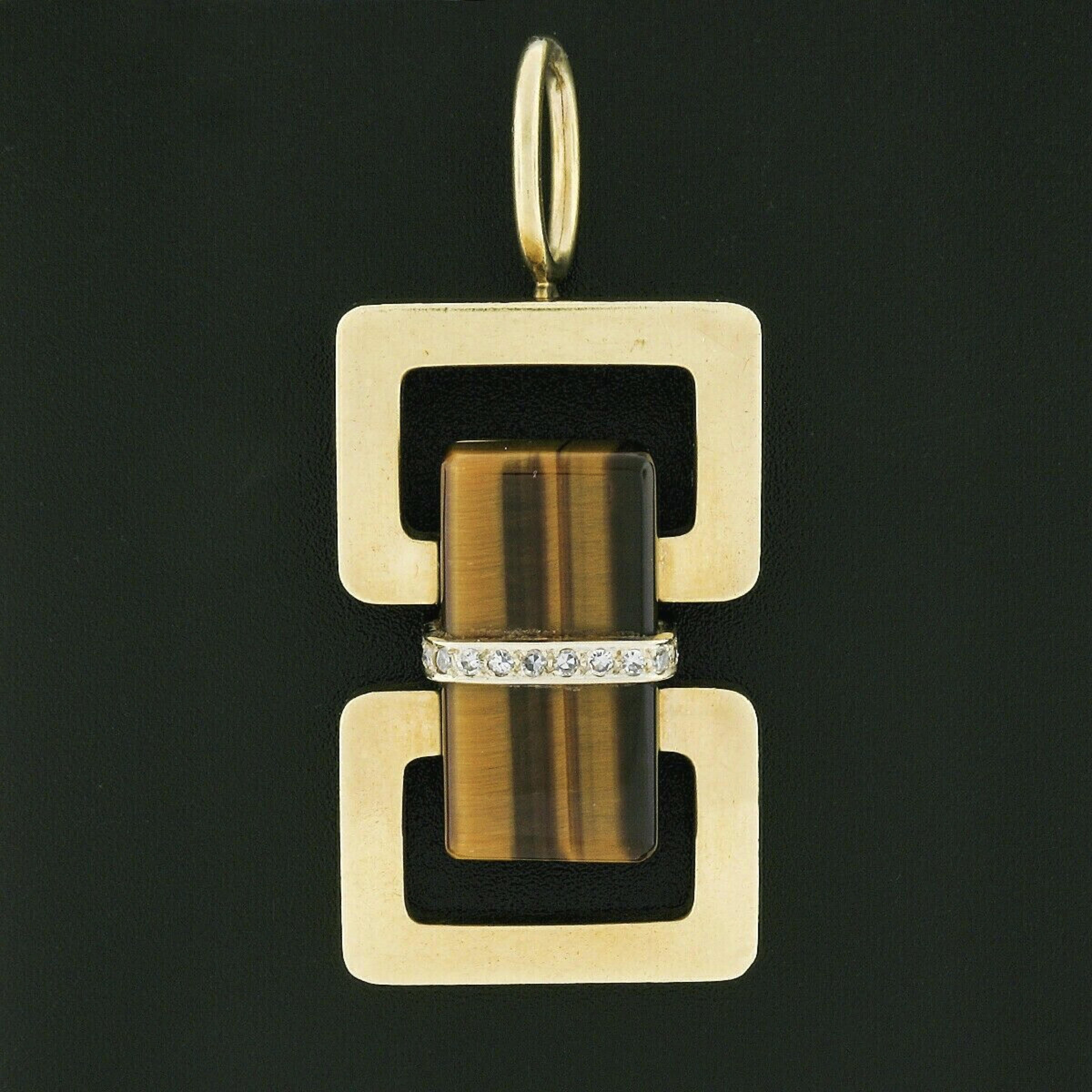 Here we have a magnificent vintage statement pendant that was crafted in solid 18k yellow gold and features a neat geometric design with a large rectangular polished cut tiger's eye set at the center of the dual open rectangular shaped design. The