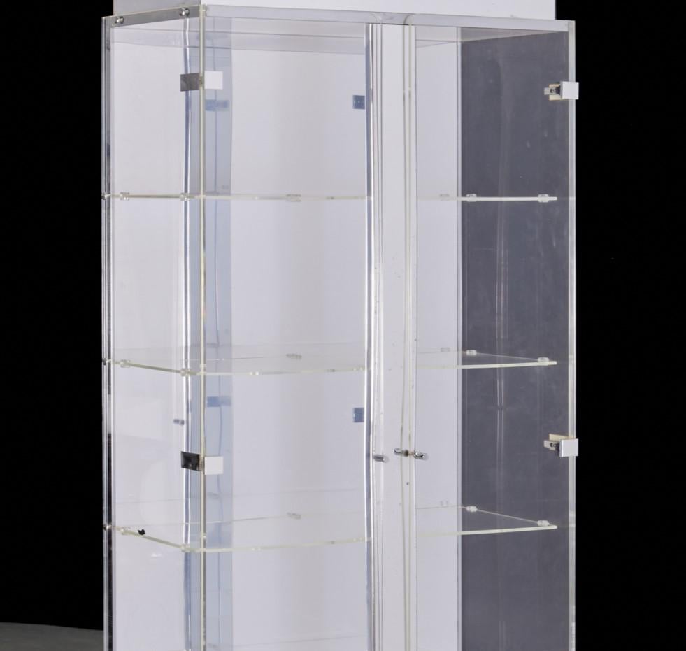 A circa. 1970's/80's, mirrored, lighted acrylic display cabinet with 4 acrylic shelves, unmarked. The interior back of the cabinet is fully mirrored. The top and base are sheathed in mirrored glass and there is a vertical central mirrored column at