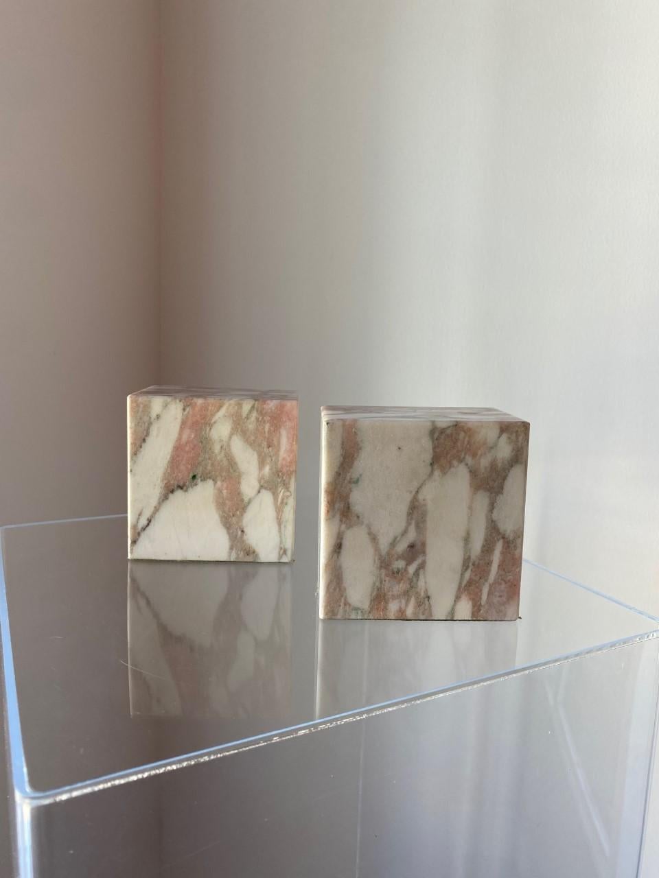 Beautiful pair of modernist marble bookends by Vermont Marble Company. These sizeable pieces of marble are captivating as they are commanding. The veining that develops on the pink marble with pink and beige undertones ondulates as the shape forms