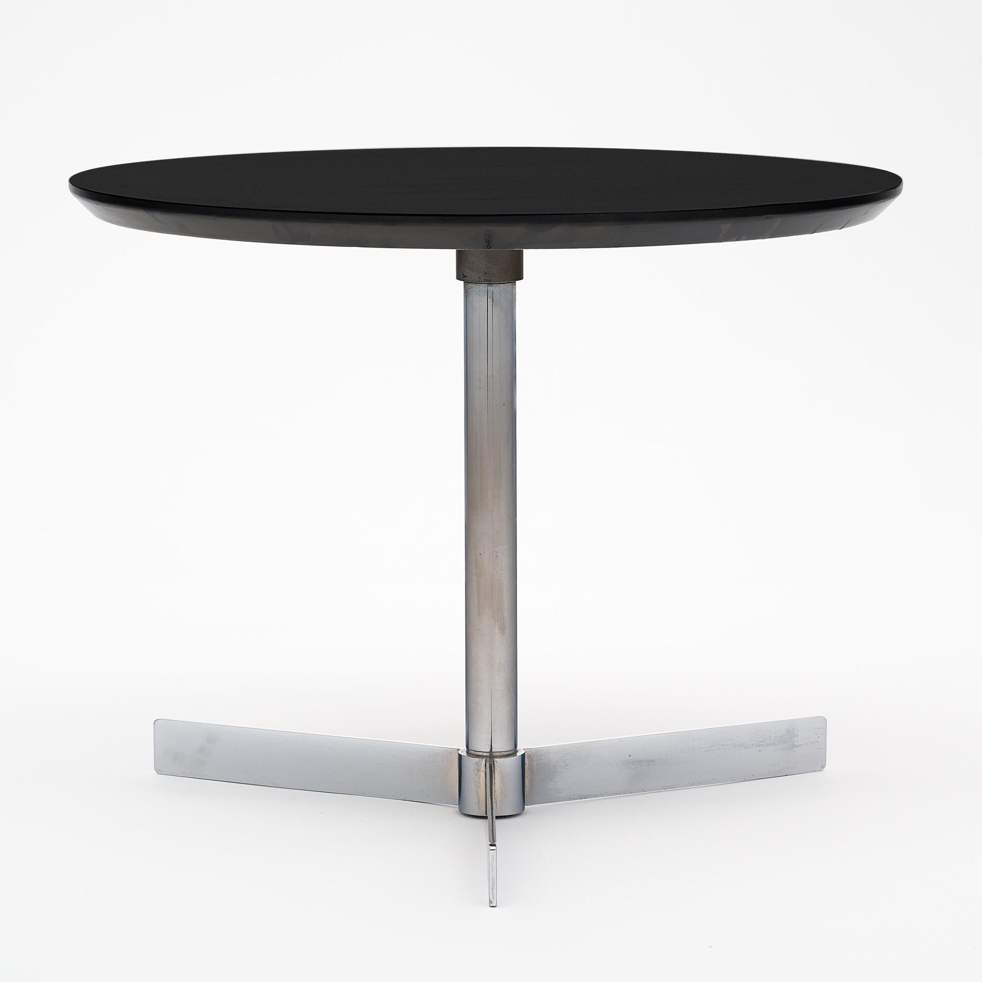 Mid-Century Modern side table, French, made with a tripod chromed steel base and a black lacquered wooden top.