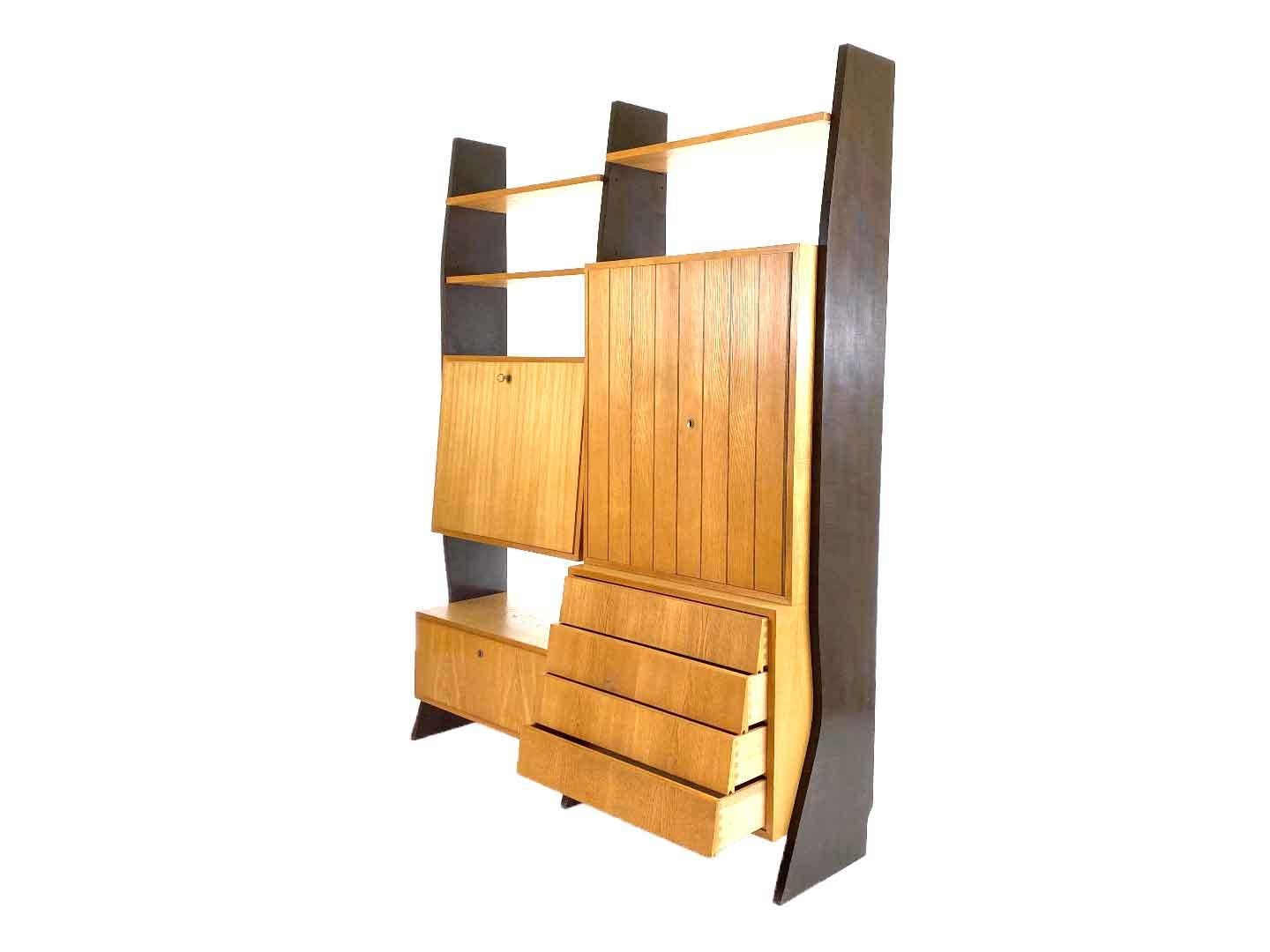 Vintage modernist wall furniture with secretary by erich stratmann for idee möbel, produced in 1959 in Germany. The wall furniture has two doors with two shelves behind, one lap, four drawers, three shelves and a secretary with light. The wall