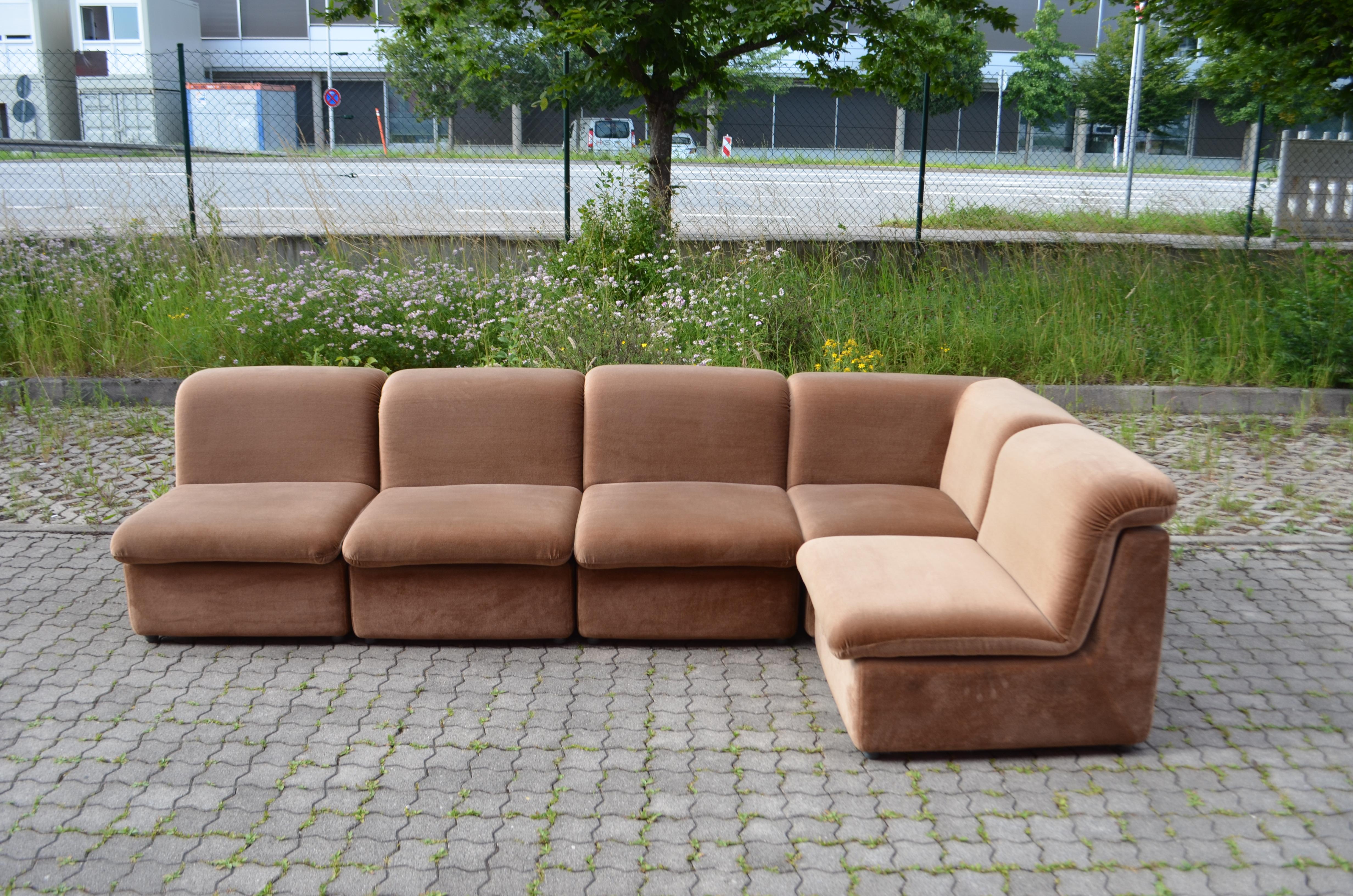 This Modular sectional sofa was manufactured in Germany.
It is a pure 70ties design with timeless modern shape.
The fabric is Velor and has a bright brown color with a soft touch.
The frame of every element is made of hardfoam/ Polysterene.
It is