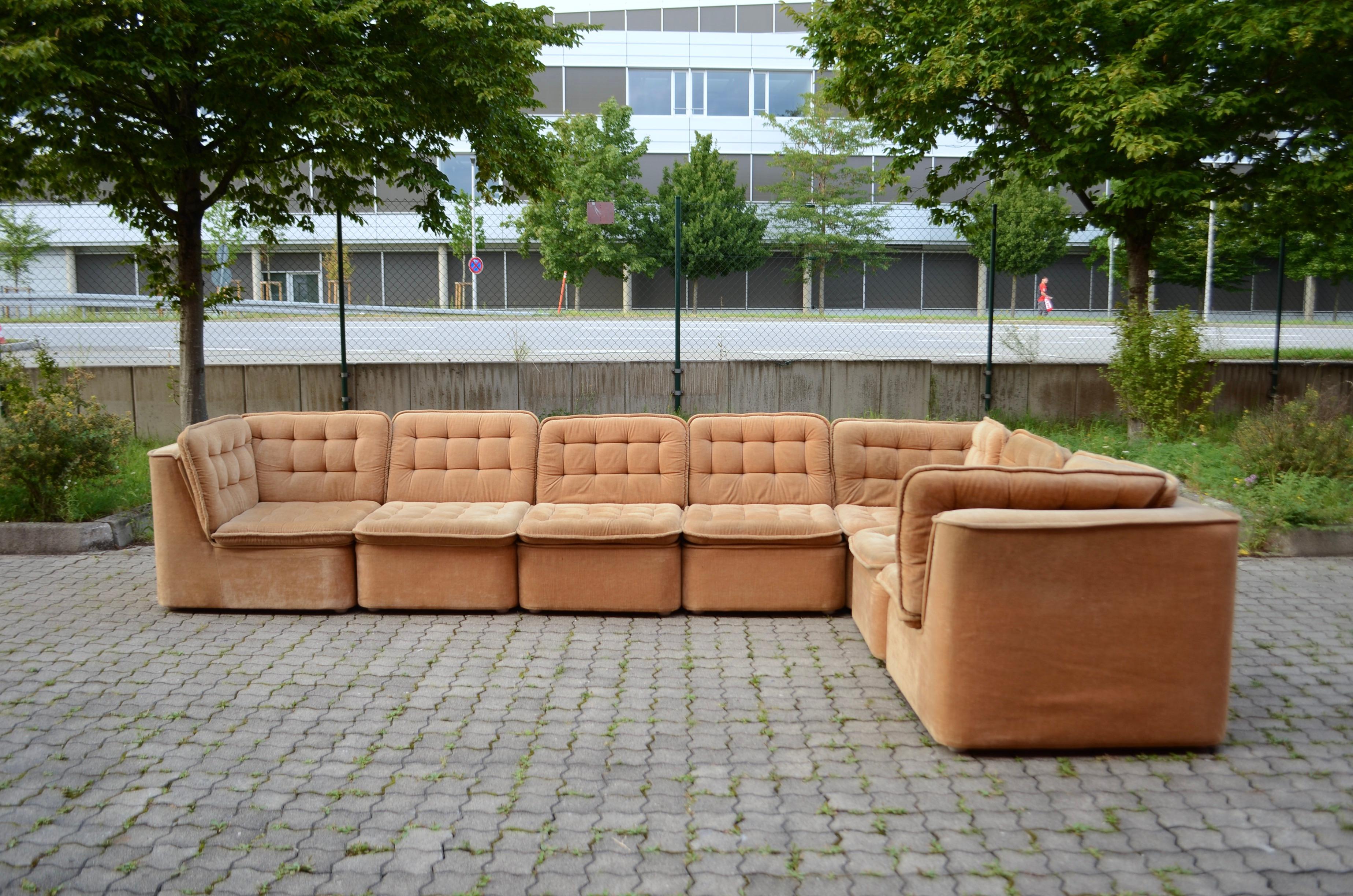 This modular sectional sofa was manufactured in Germany and showcases an authentic 1970s design with a timeless, modern aesthetic.
The upholstery is velour in a refined champagne color, offering a soft, luxurious touch. Each module features a solid
