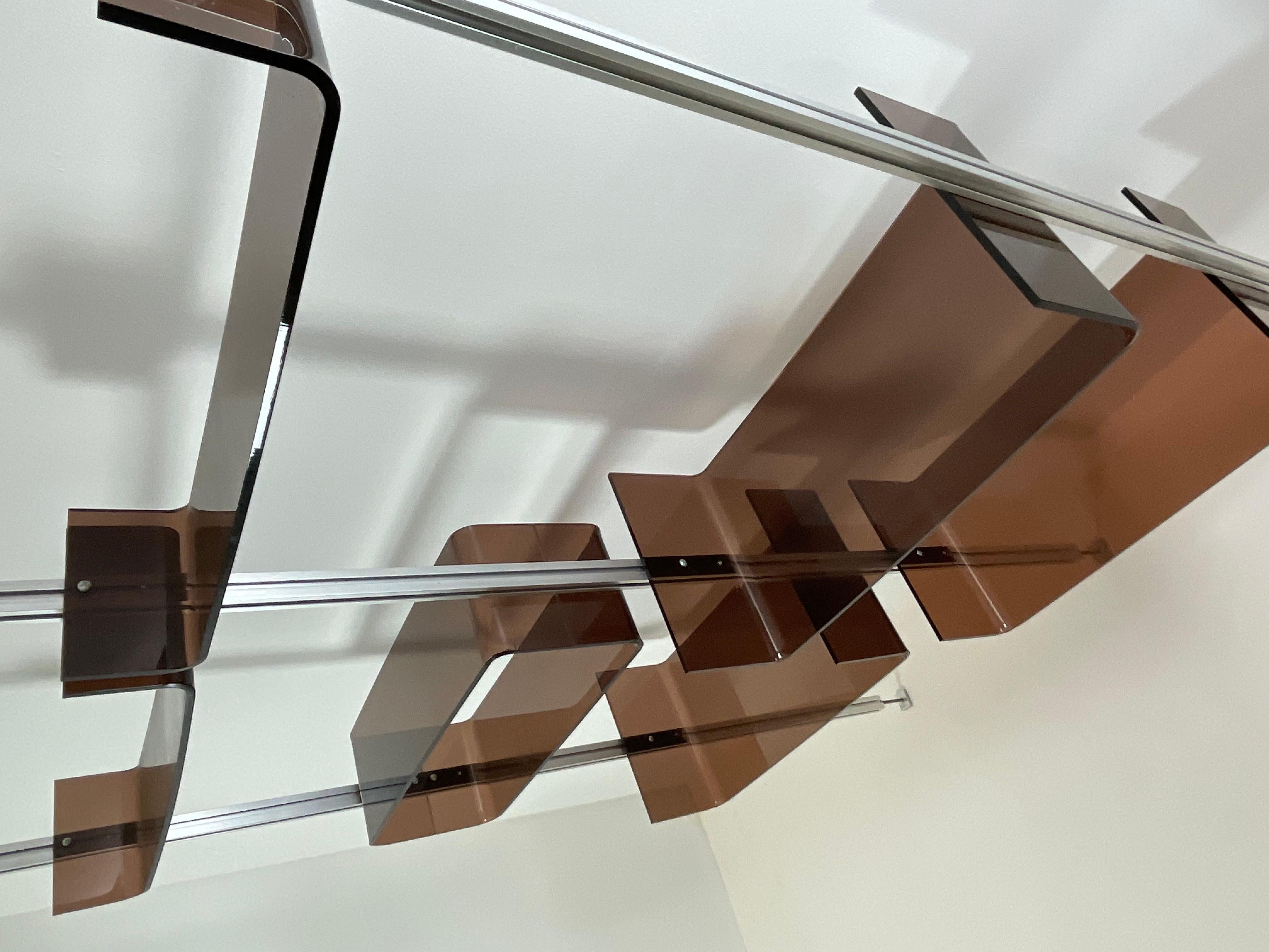 Modular shelf by Michel Ducaroy and produced by Roche Bobois in France around 1970. The vertical aluminum supports support quality brown Plexiglas shelves. It can also be used as a room divider. It can be extended in height to a maximum of 270 cm