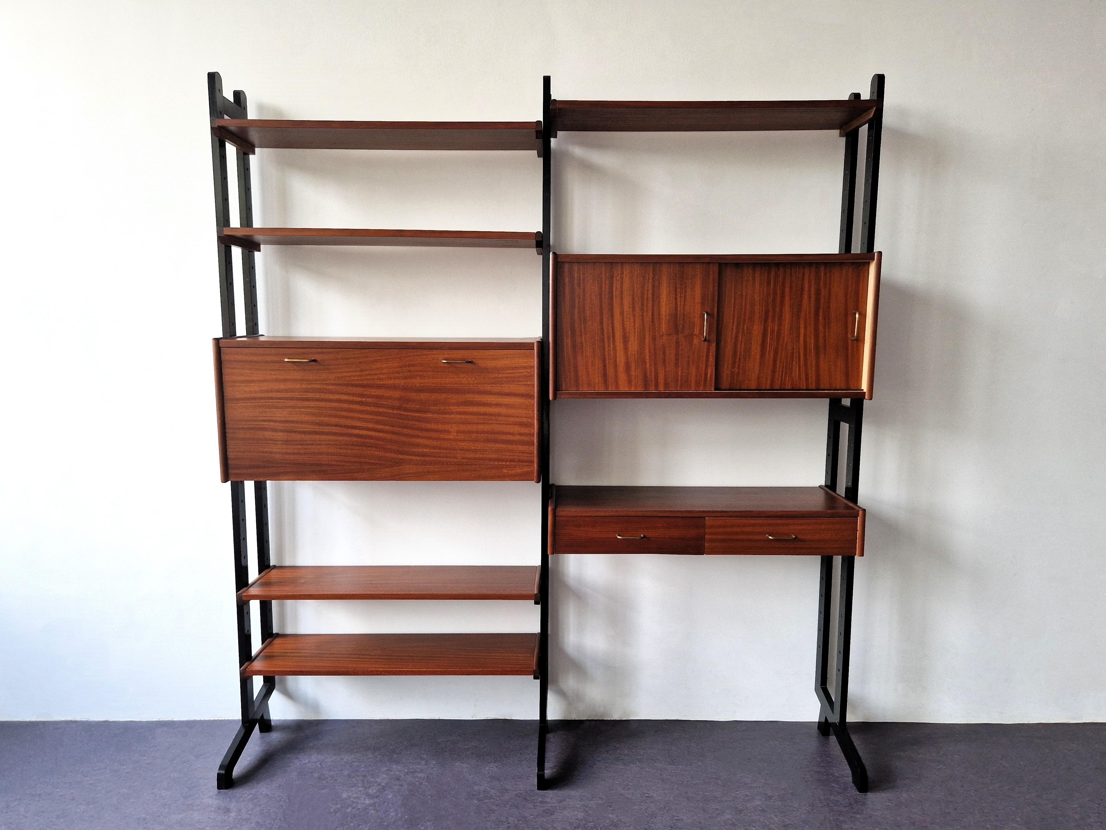 This lovely wall unit was produced by the Dutch furniture manufacturer Simpla Lux in the 1960's. It is a modular system that can be arranged according to your own wishes. The unit consists out of 3 black uprights, 5 shelves, a set of drawers, a