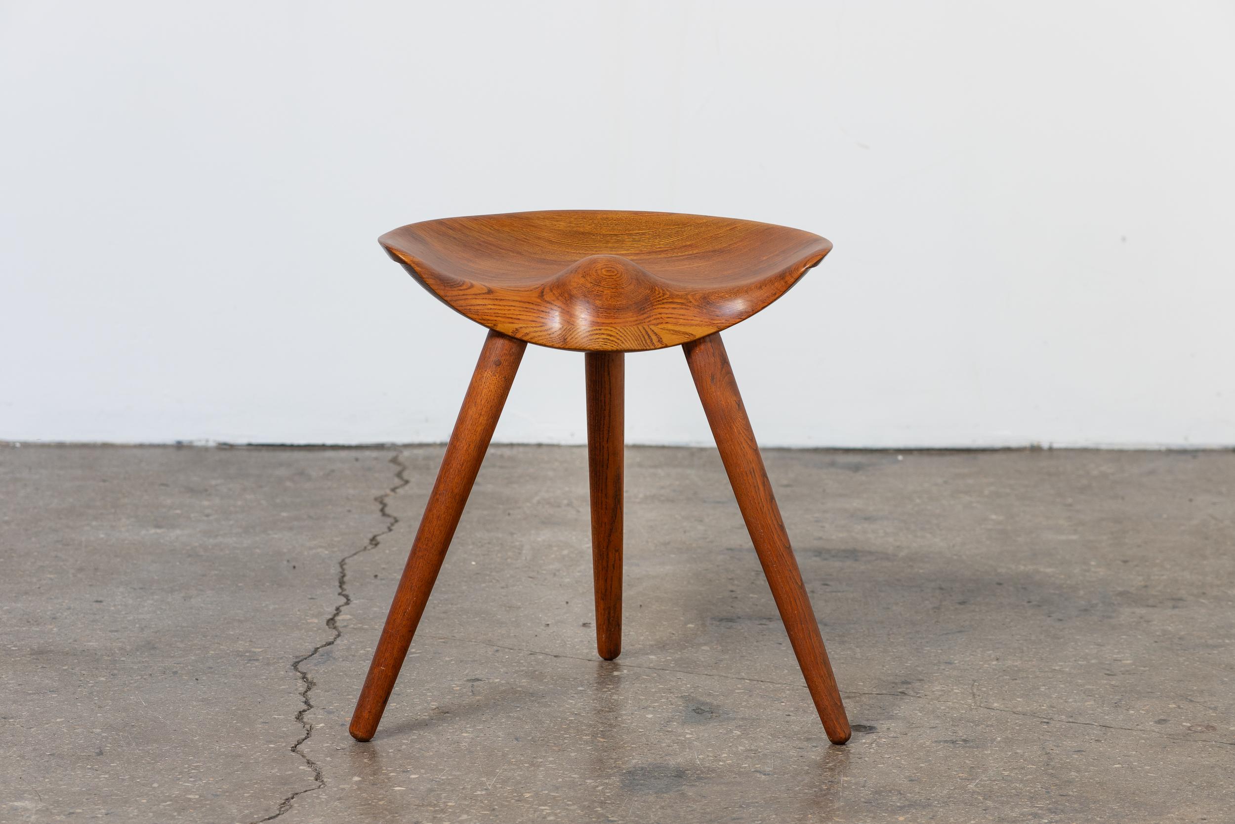 Sgabello scultoreo vintage disegnato da Mogens Lassen per K. Thomsen. Questo iconico sgabello è stato presentato alla prestigiosa mostra della Danish Cabinetmaker's Guild nel 1942. Ispirato ai tradizionali sgabelli da calzolaio in legno, il design