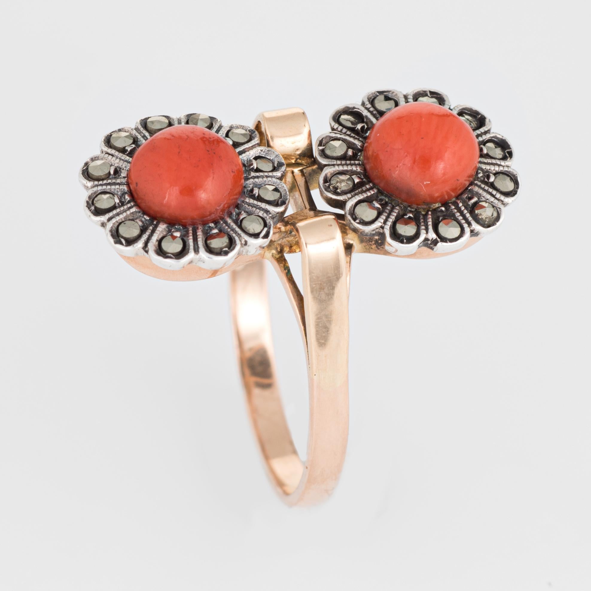 Finely detailed vintage coral & marcasite double flower ring (circa 1950s to 1960s) crafted in 18 karat yellow gold. 

Two pieces of coral each measure 5.7mm, accented with marcasite.    

The charming double flower motif represents two lives joined