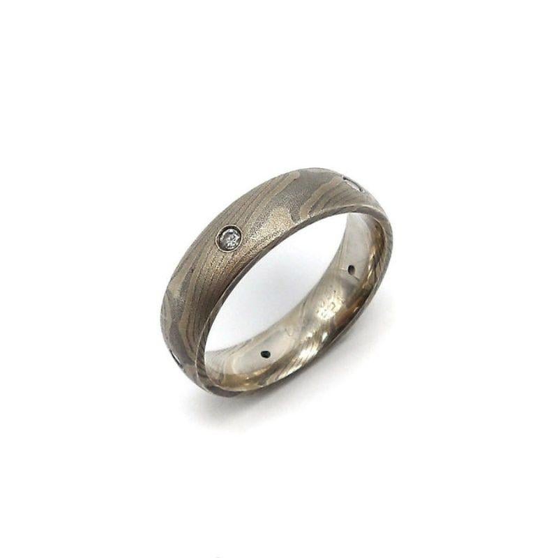 This is a gorgeous Mokume gane sterling silver and palladium ring with five flush-set single cut diamonds. Mokume gane is a very unique Japanese metalworking process where mixed metals like palladium and sterling silver are layered on and