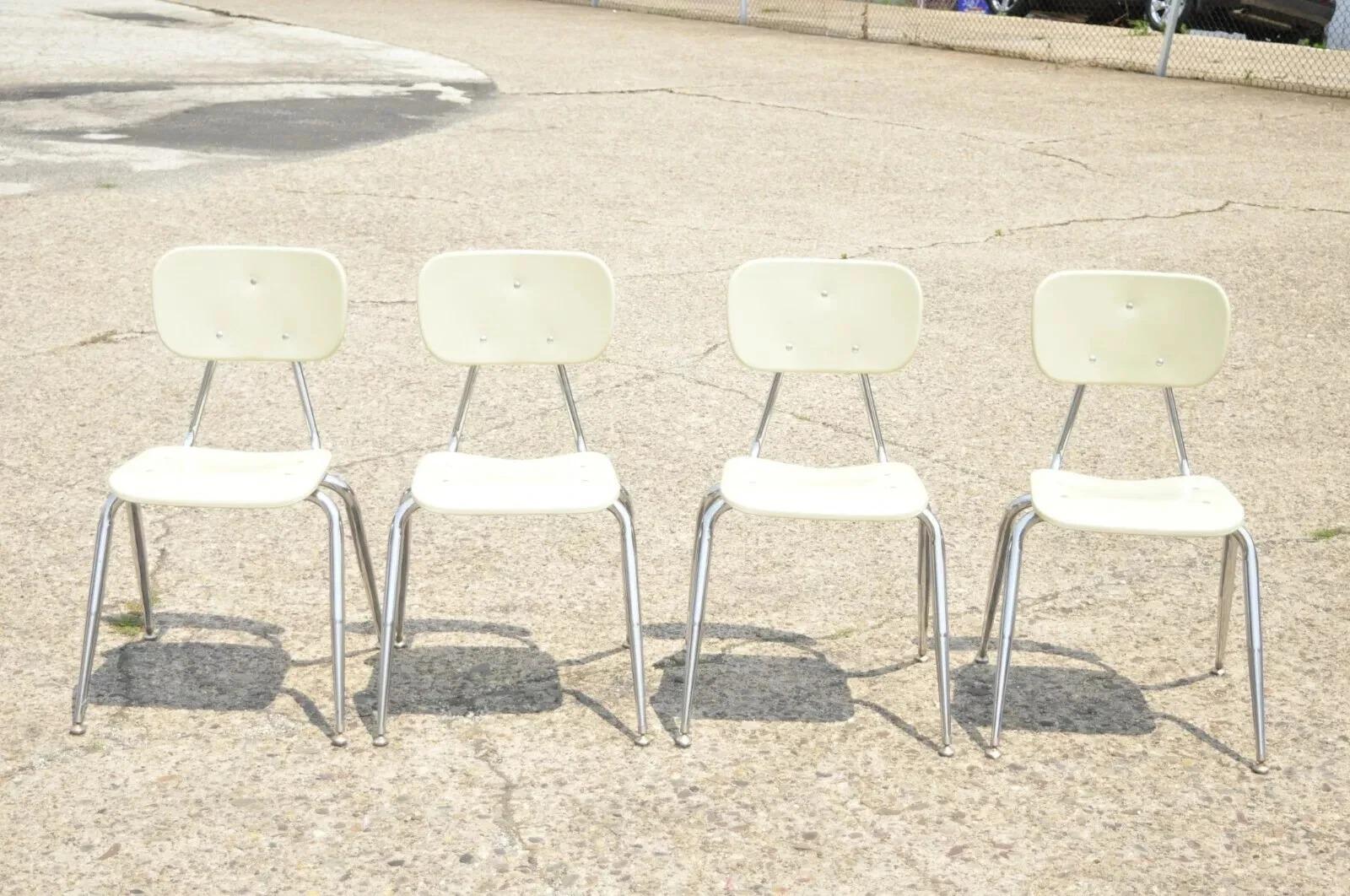 Set di 4 sedie per la scuola impilabili con base in metallo e cromo. L'articolo è caratterizzato da schienale e seduta in plastica stampata, gambe in metallo, forma impilabile, finitura beige, artigianato americano di qualità. Circa alla fine del XX