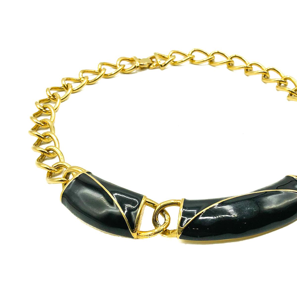 A Vintage Monet Enamel Collar. Crafted in gold plated metal and lustrous black enamel. Featuring a fabulous large link chunky chain giving way to a trio of impressive modernist black enamelled sections. In very good vintage condition, signed and