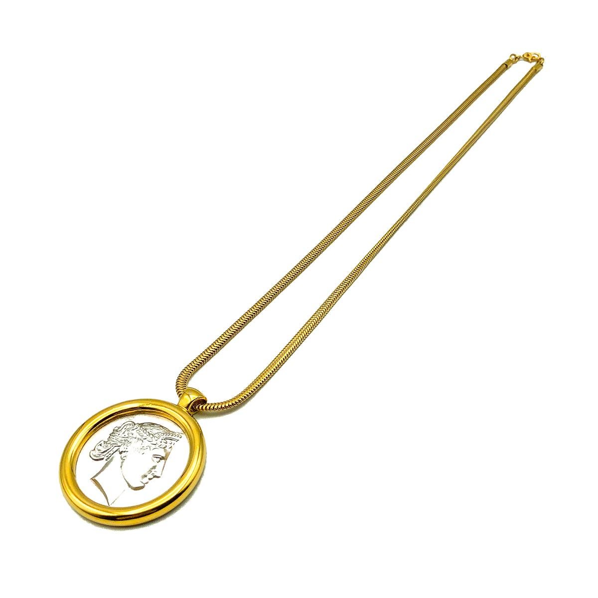 A Vintage Monet Medallion Necklace. Gold plated and silver tone metal. Featuring a statement coin medallion style pendant with a snake link chain.  Signed, in very good vintage condition, chain approx. 51cm with a pendant diameter of approx. 3.5cm.