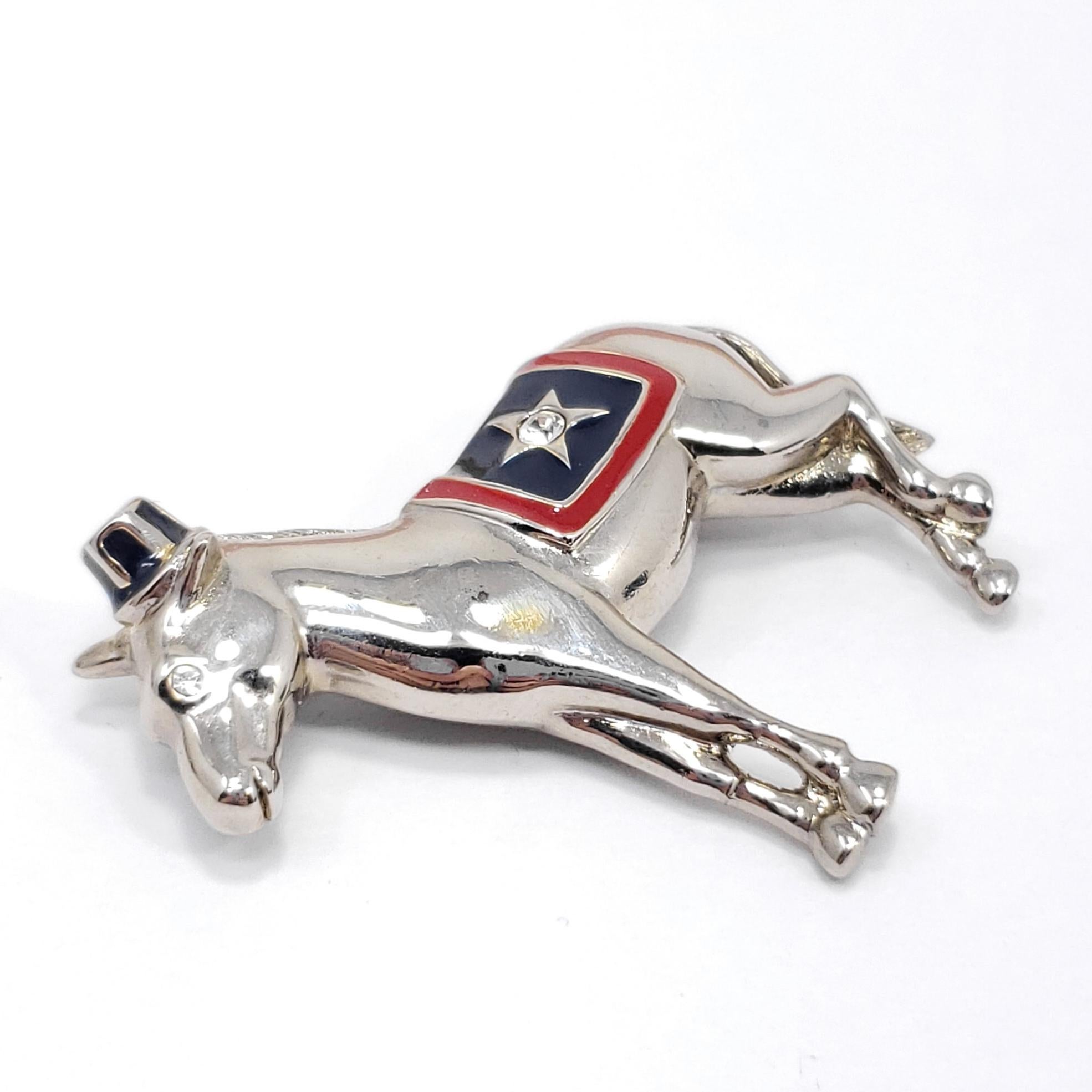This patriotic pin features a silver-tone donkey, accented with clear crystals and red & blue enamel. By Monet.

Marks / hallmarks / etc: Monet