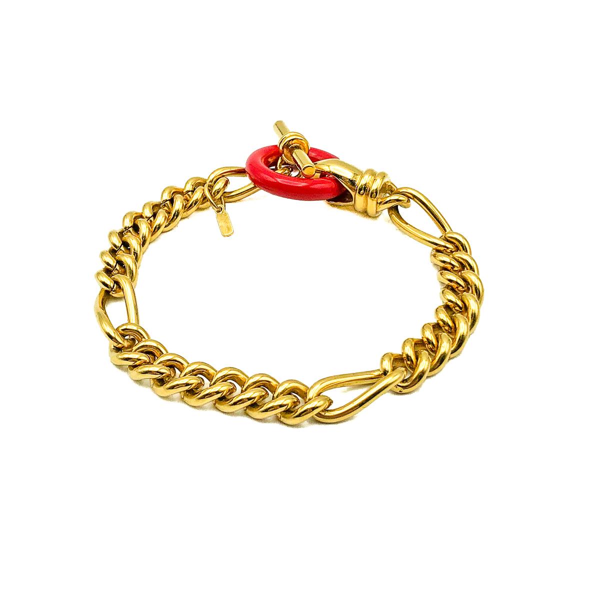 A vintage Monet T Bar Bracelet with a pop of vibrant red for a twist. Crafted in weighty gold plated metal with a red resin hoop. Signed. In very good vintage condition. Approx. 19cms. A very cool bracelet that is cleverly unconventionally
