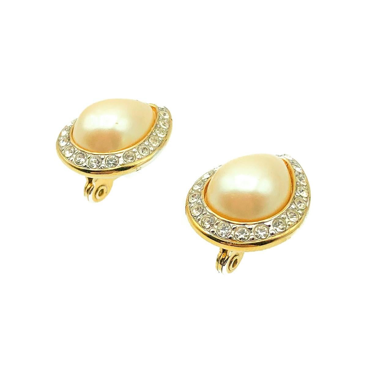 A Vintage Monet Pearl Teardrop Earring. Crafted in gold plated metal set with a glass teardrop faux pearl and crystals. Very good vintage condition, 2.2cms, signed.

Established in 2016, this is a British brand that is already making a name for