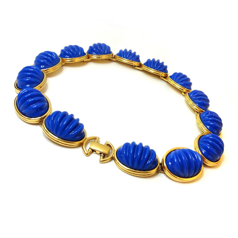 This is a 1980s Monet royal blue modern necklace with 14 .63 inch thick bold ridged oval pieces set in gold tone metal. They are linked together for 16.5 inch and are considered to be a choker.
I can imagine you wearing this necklace strolling along