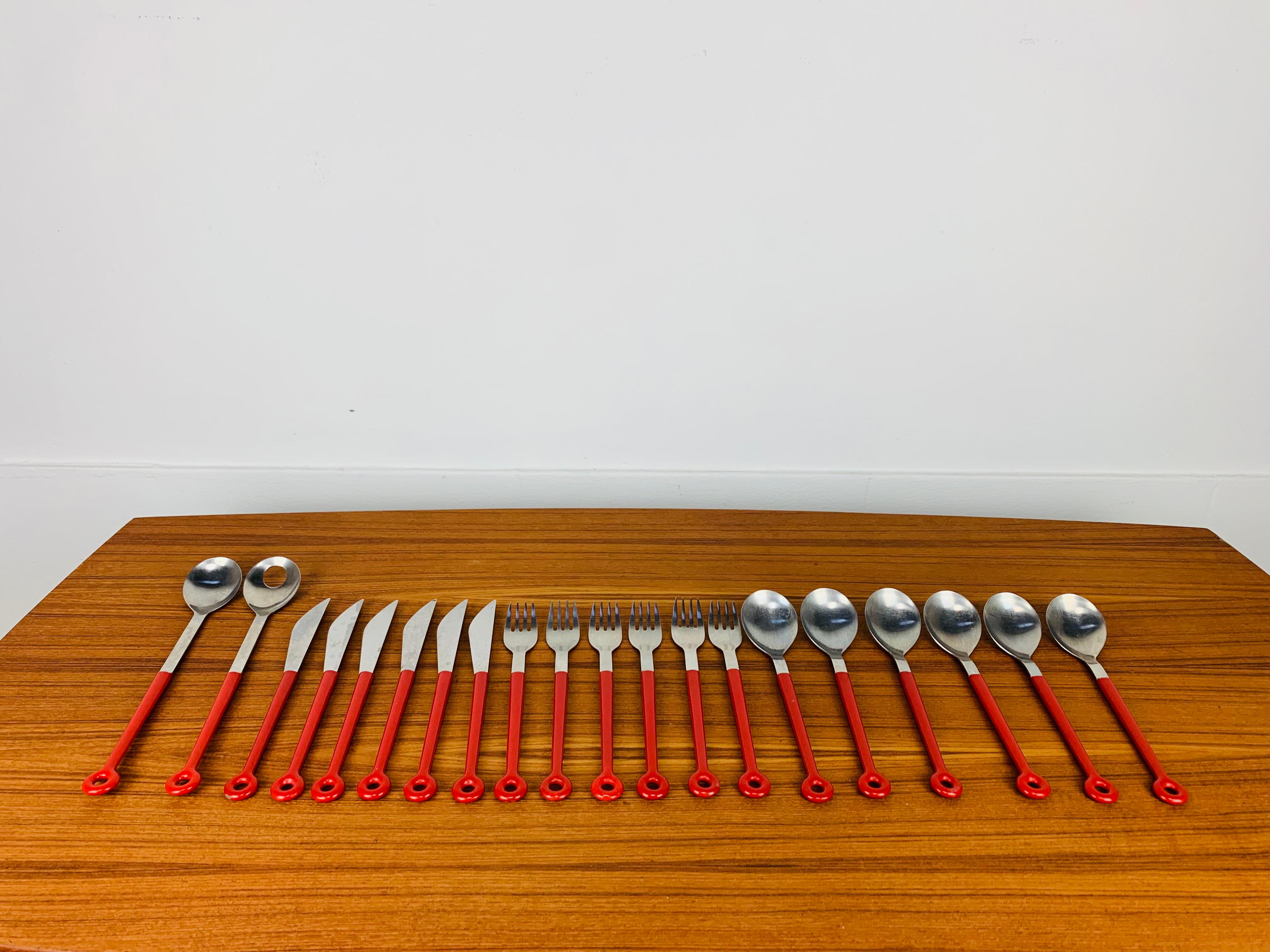 Rare ensemble vintage et original de couverts Mono Ring par Peter Raacke pour Mono Germany. Il a été conçu en 1962 et est fabriqué en acier inoxydable et en plastique rouge. Il est estampillé 