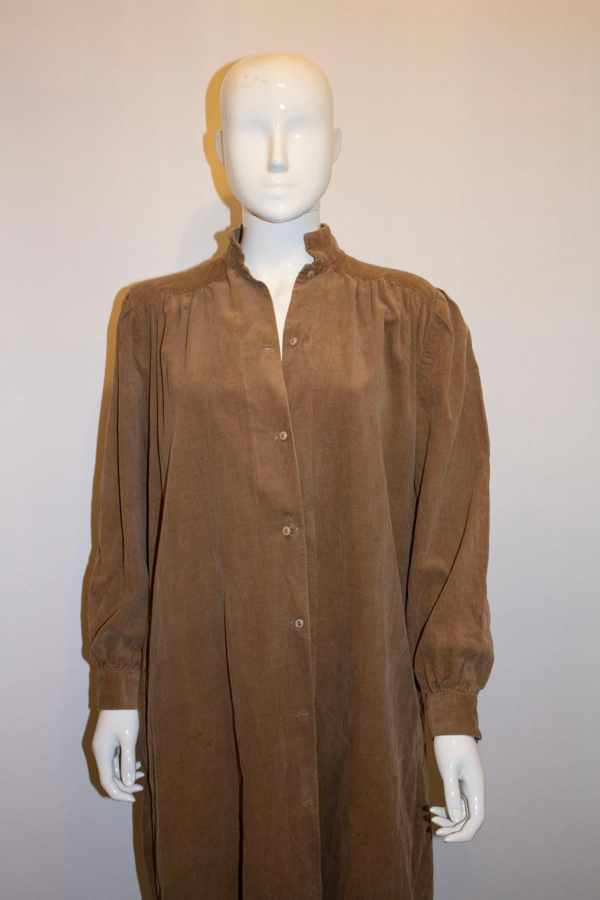 A great vintage dress for Fall by Monsoon. The dress is in a beige corduroy cotton, and can be worn as a dress or an over dress. It has a stand up collar, button front opening and gathering on the shoulders. It has a 2 button cuff, pocket on either