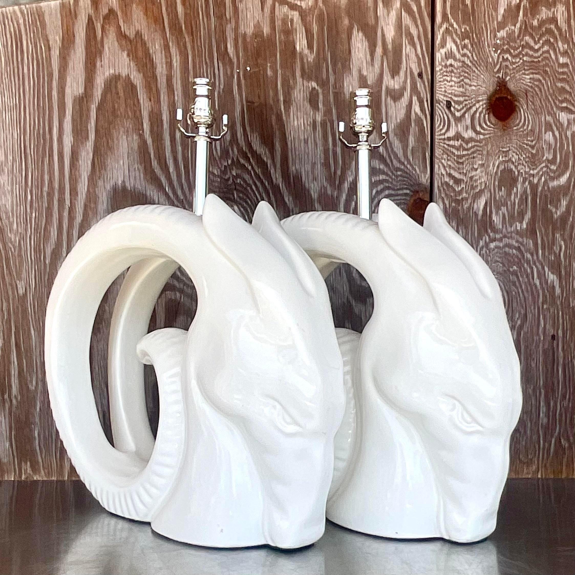 An extraordinary pair of vintage 80s table lamps. A chic pair of glazed ceramic rams heads in a high gloss finish. Monumental in size and drama. Fully restored with all new hardware and wiring. Acquired from a Palm Beach estate.