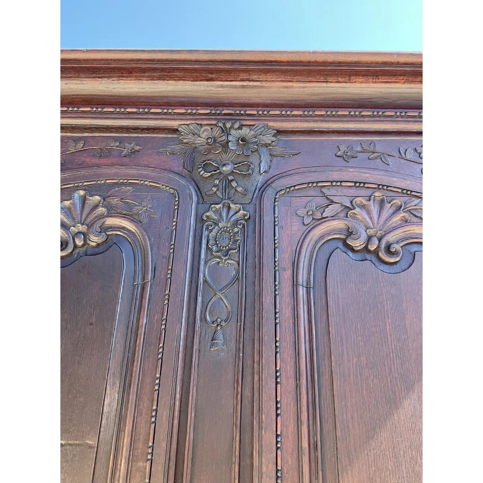 A truly spectacular vintage French hand carved armoire. A monumental rustic masterpiece with original hardware and hand carved detail. Lots of great interior storage. Acquired from a Palm Beach estate.
