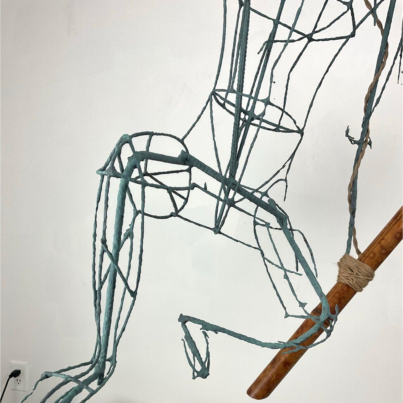 An extraordinary fusion of art and function, this handcrafted wireframe hanging sculpture lamp captivates with its dynamic, fluid form. The intricate metal framework, shaped into a striking human figure, exudes a sense of movement and grace.