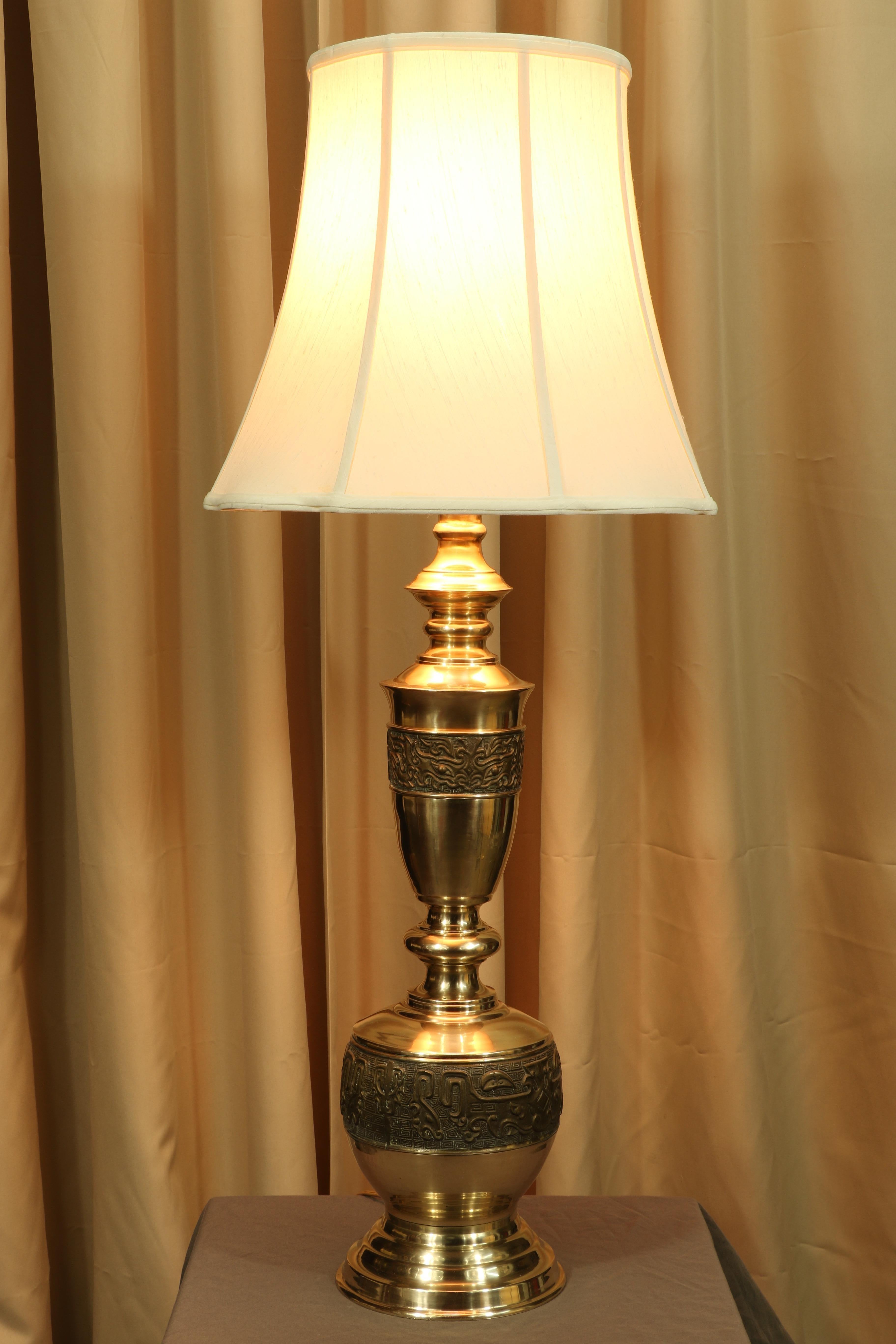 The beautiful brass patina makes this James Mont mid-century lamp a standout. If a lamp can be exciting, this is it. It is encircled with etching and Asian motif symbols around the outside. It is a beautiful example of Mont's Hollywood Regency style