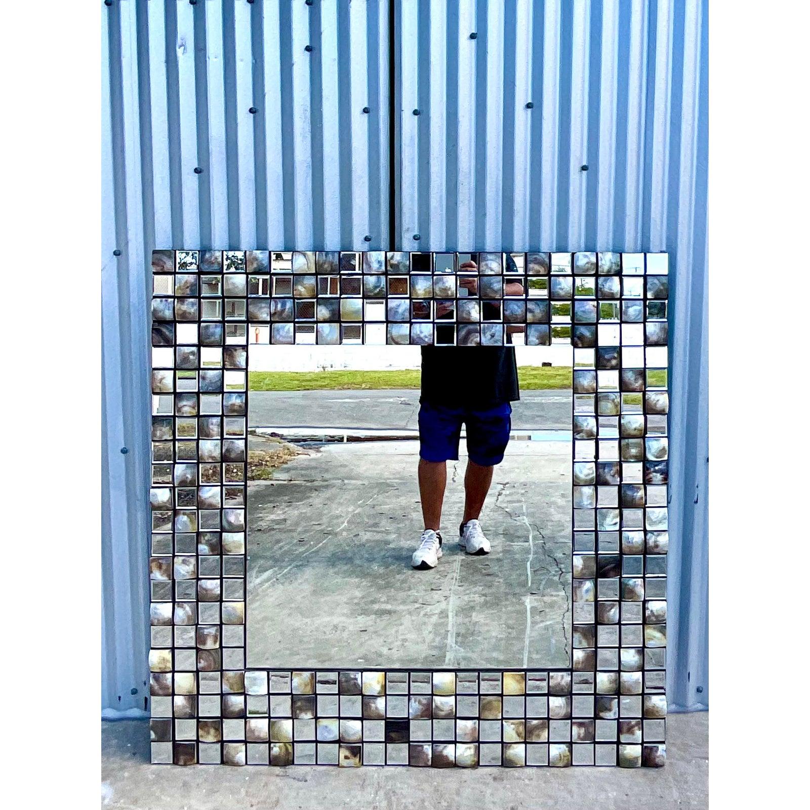 Fantastic vintage Capiz shell mirror. Beautiful square tiles of shell mixed with tile of mirror make the most beautiful modern looking frame. Monumental in size for a dramatic addition to any room. Two available.